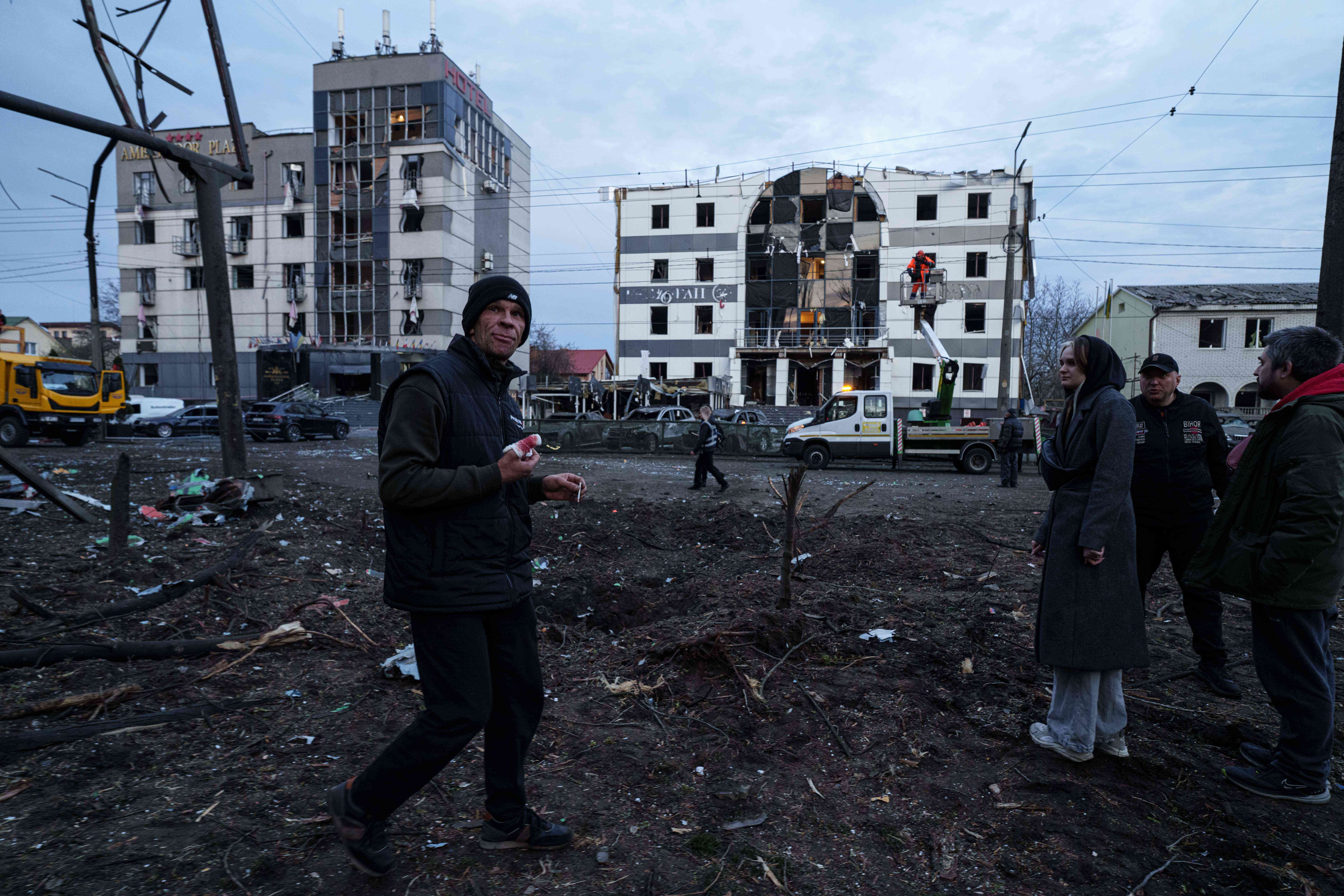 An injured man walks in front of his house damaged after a Russian strike on residential area in Kyiv
