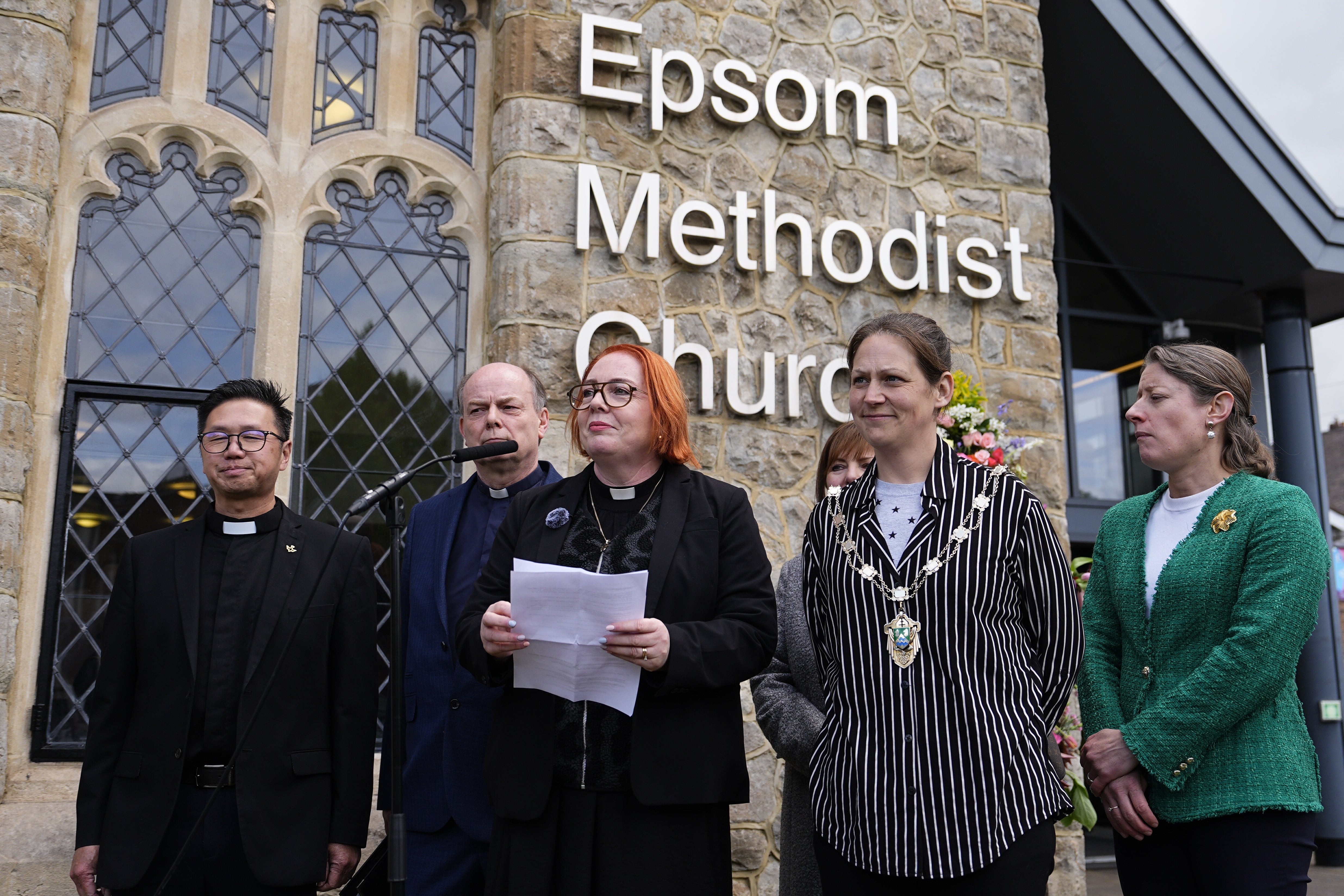 Reverend Catherine Hutton (3rd left) speaking to the media outside Epsom Methodist Church in Ashley Road