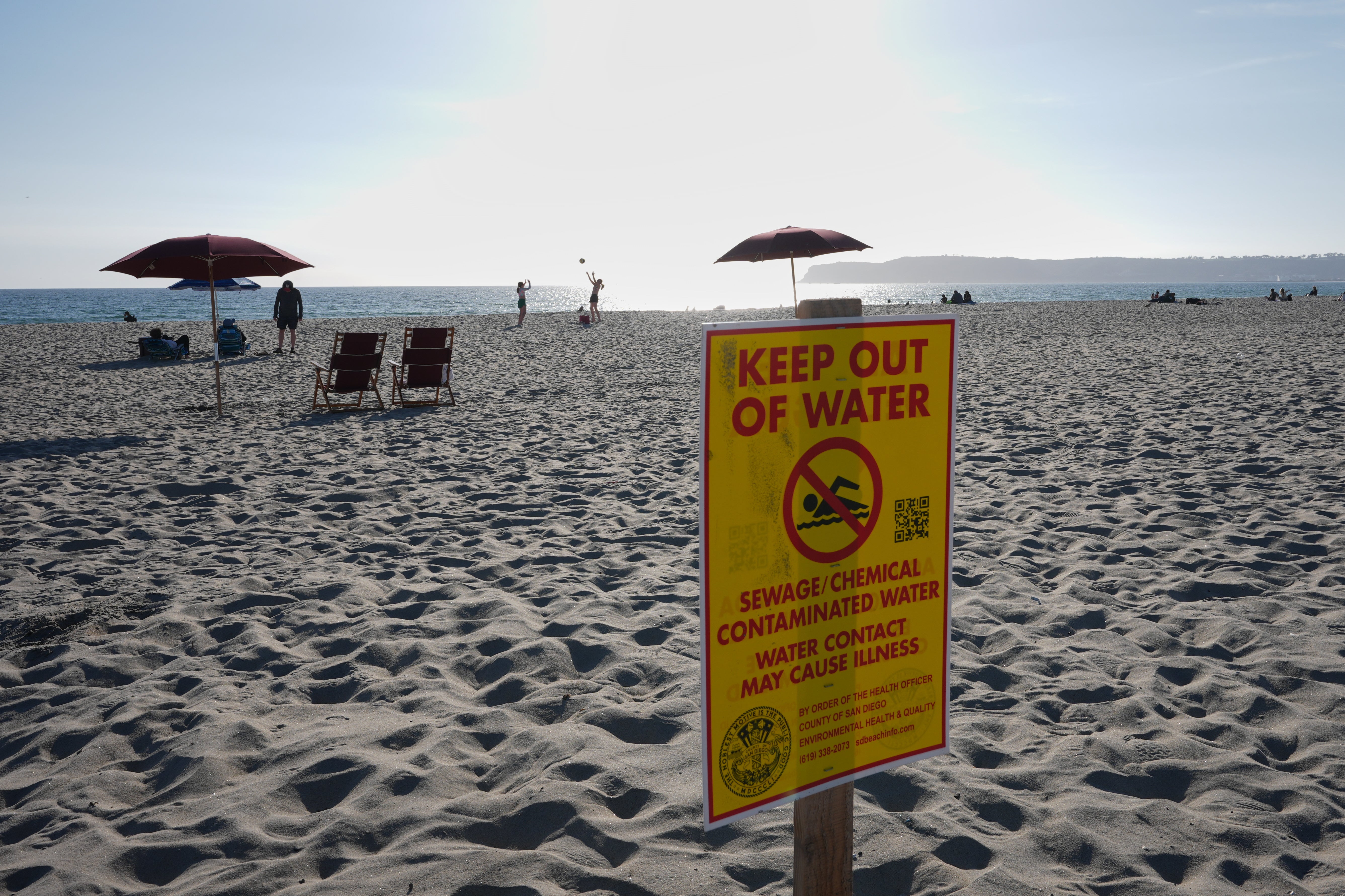 Beachgoers in Coronado are seeing these yellow warning signs as sewage carried by the Tijuana River flows into the Pacific and is pushed north along San Diego County’s coast, with up to 30 million gallons of contaminated water entering the ocean daily