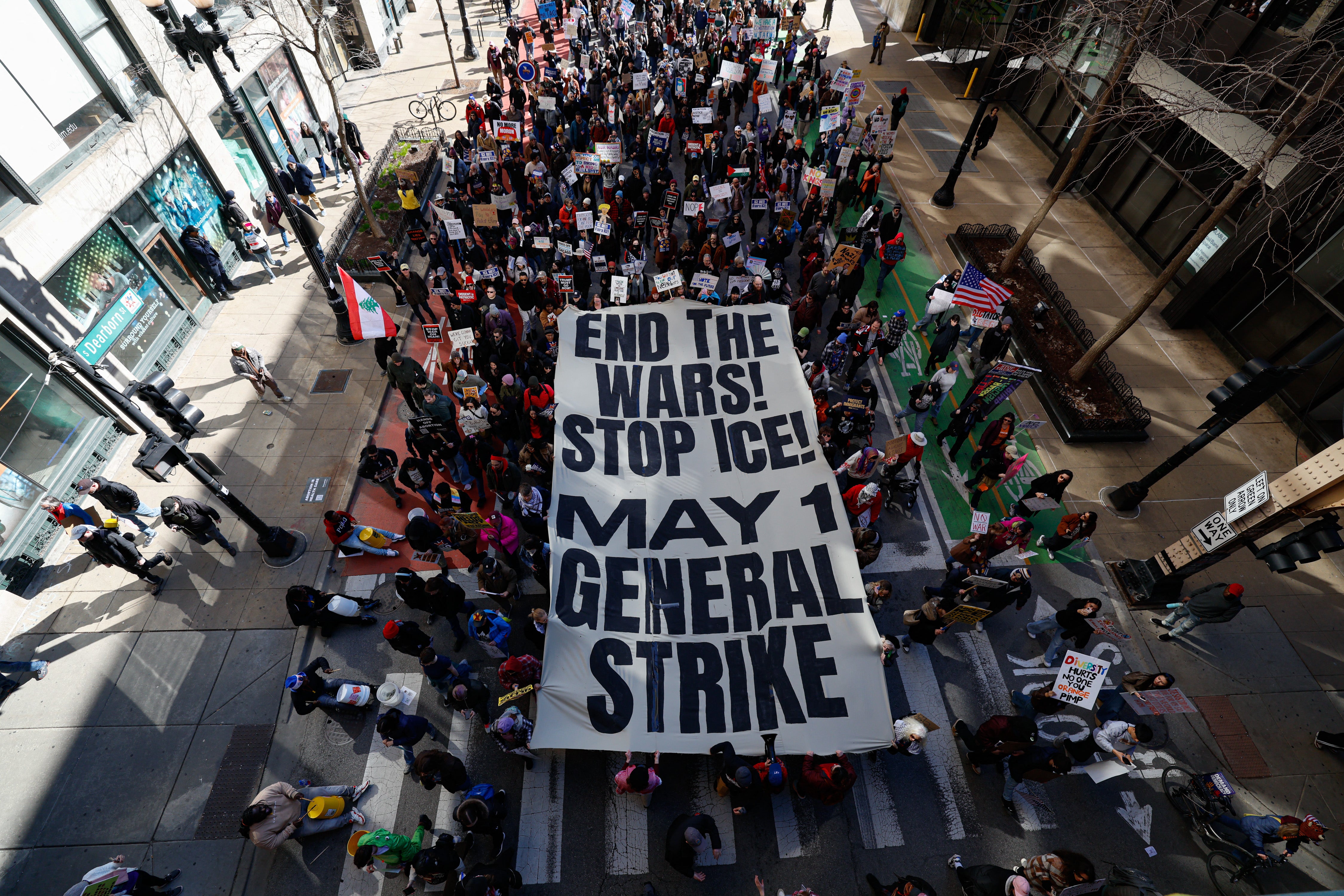 People hold a banner reading "end the wars, stop ICE, May 1 general strike" as they march during the "No Kings" national day of protest in Chicago