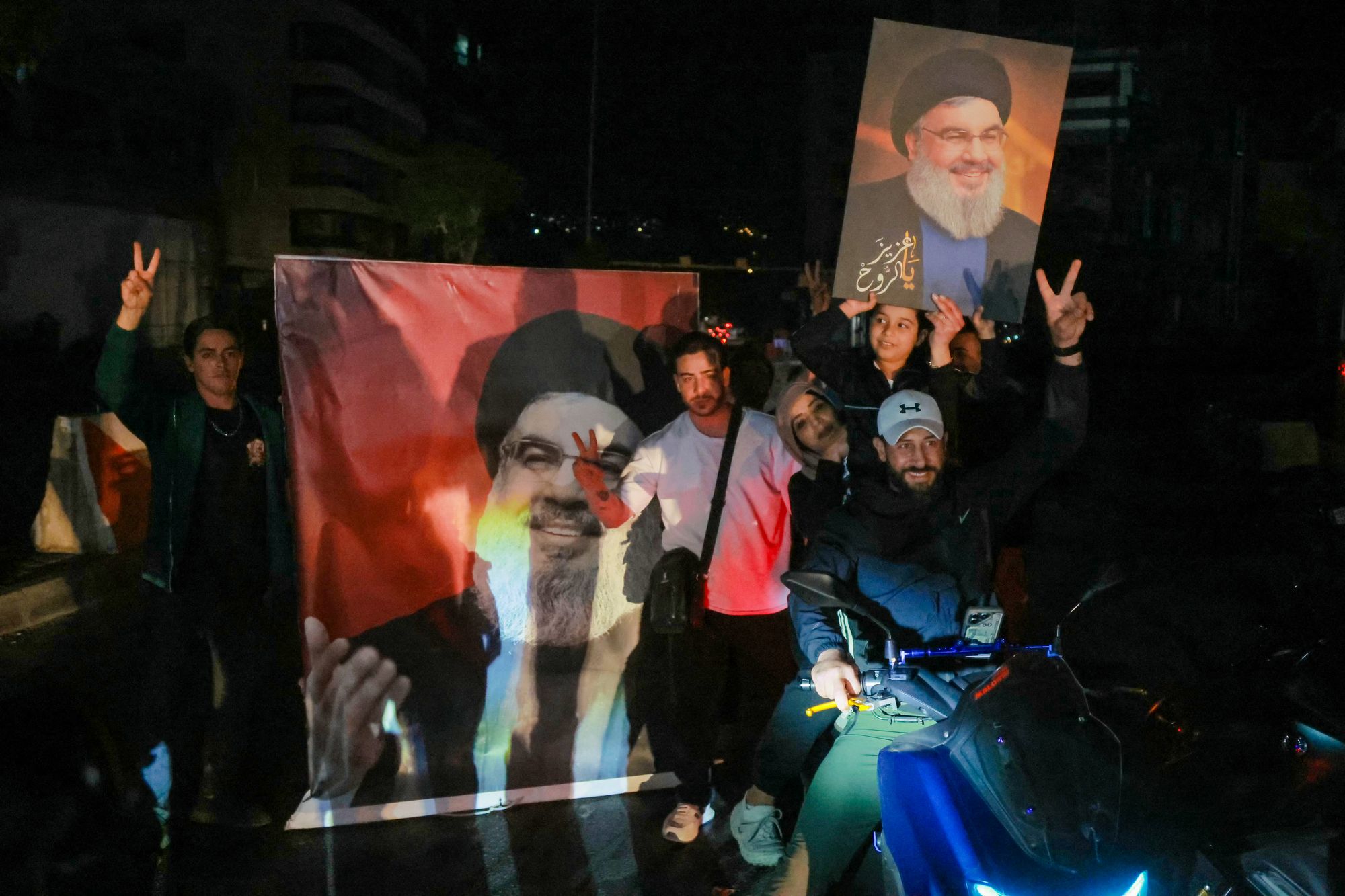 Hezbollah supporters hold photos of assassinated leader Hassan Nasrallah while celebrating the ceasefire