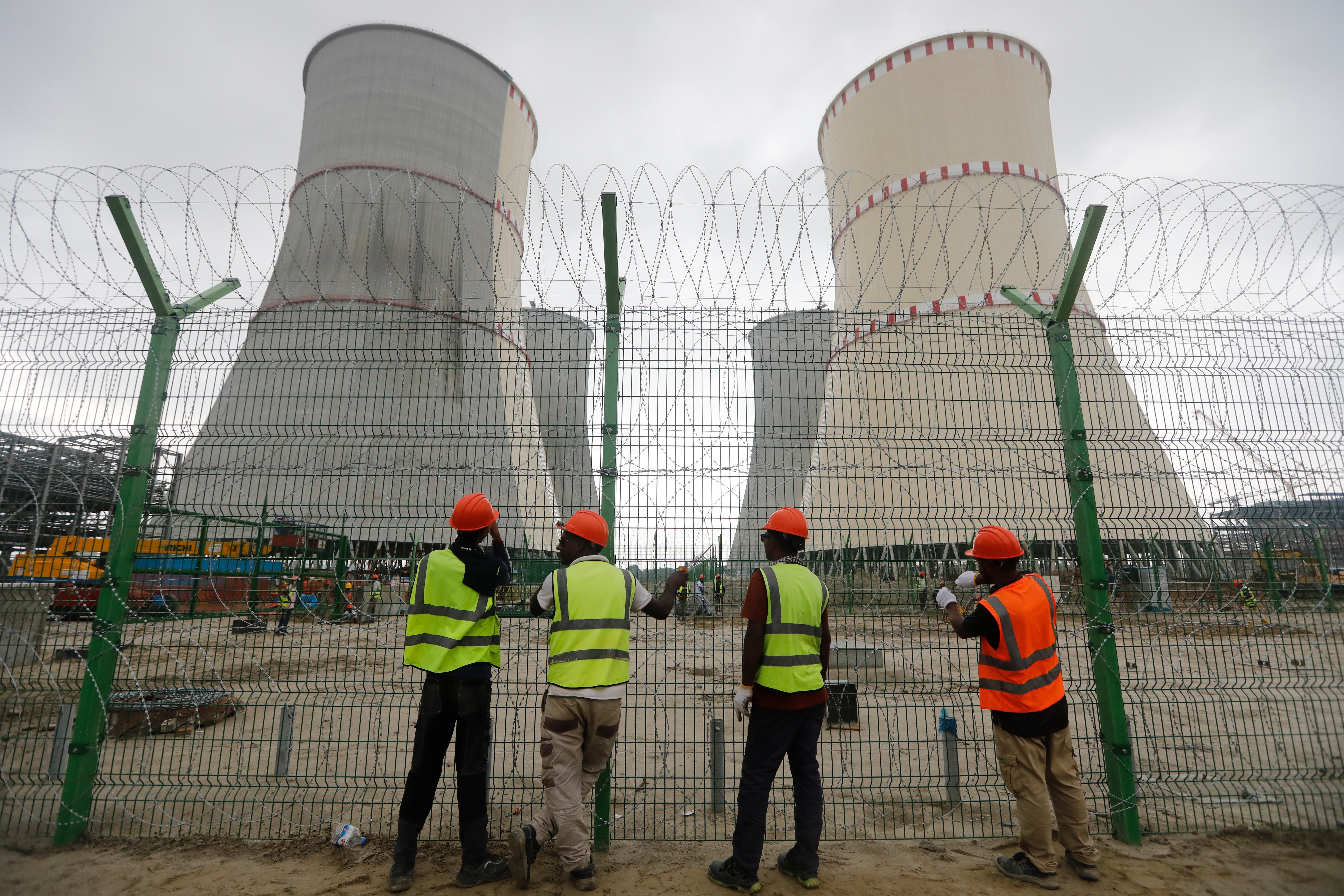 Workers fix barbed wire on the fence of the Rooppur Nuclear Power Plant at Ishwardi in Pabna, Bangladesh