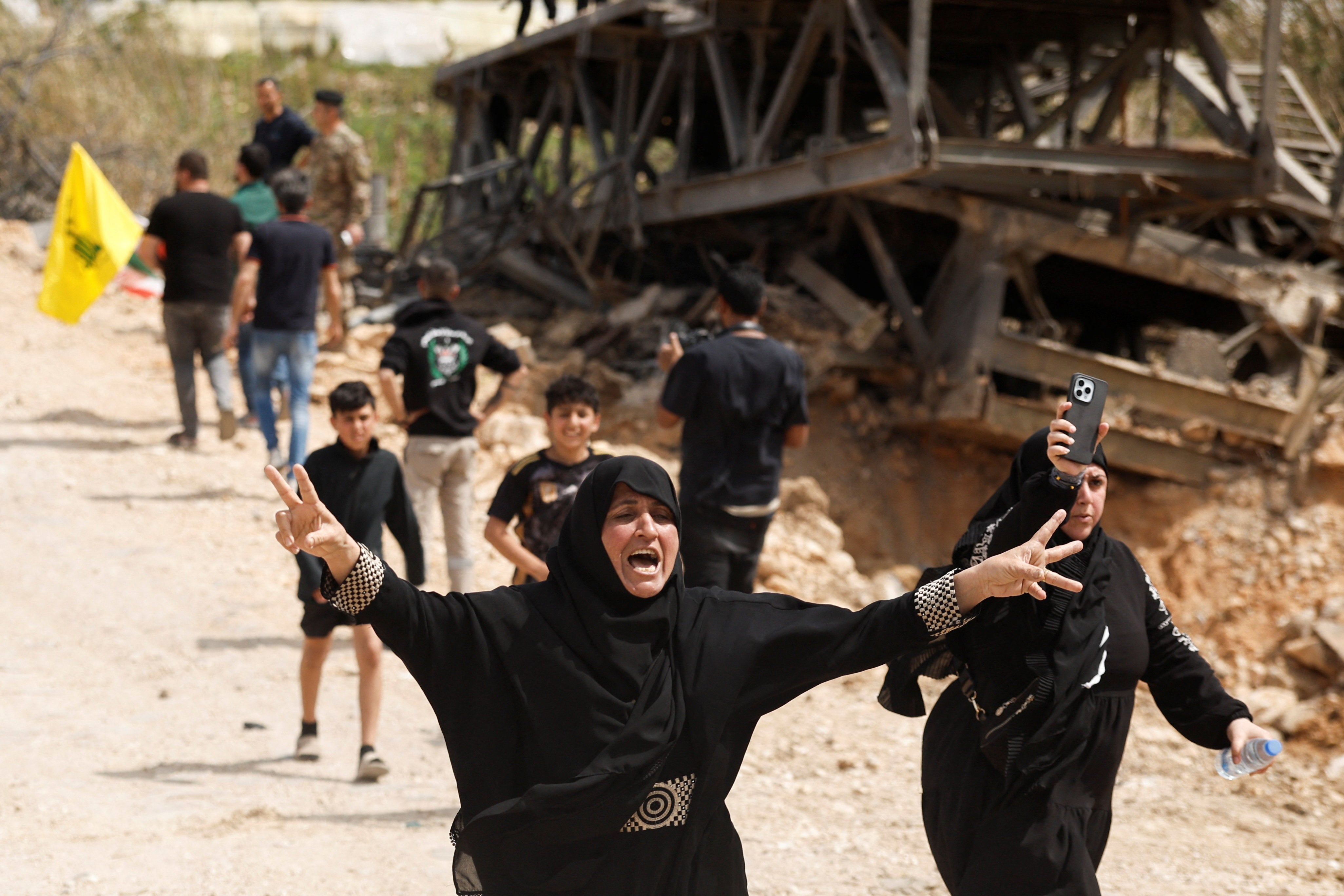 Women react as displaced people make their way back to their homes crossing the bridge linking southern Lebanon to the rest of the country