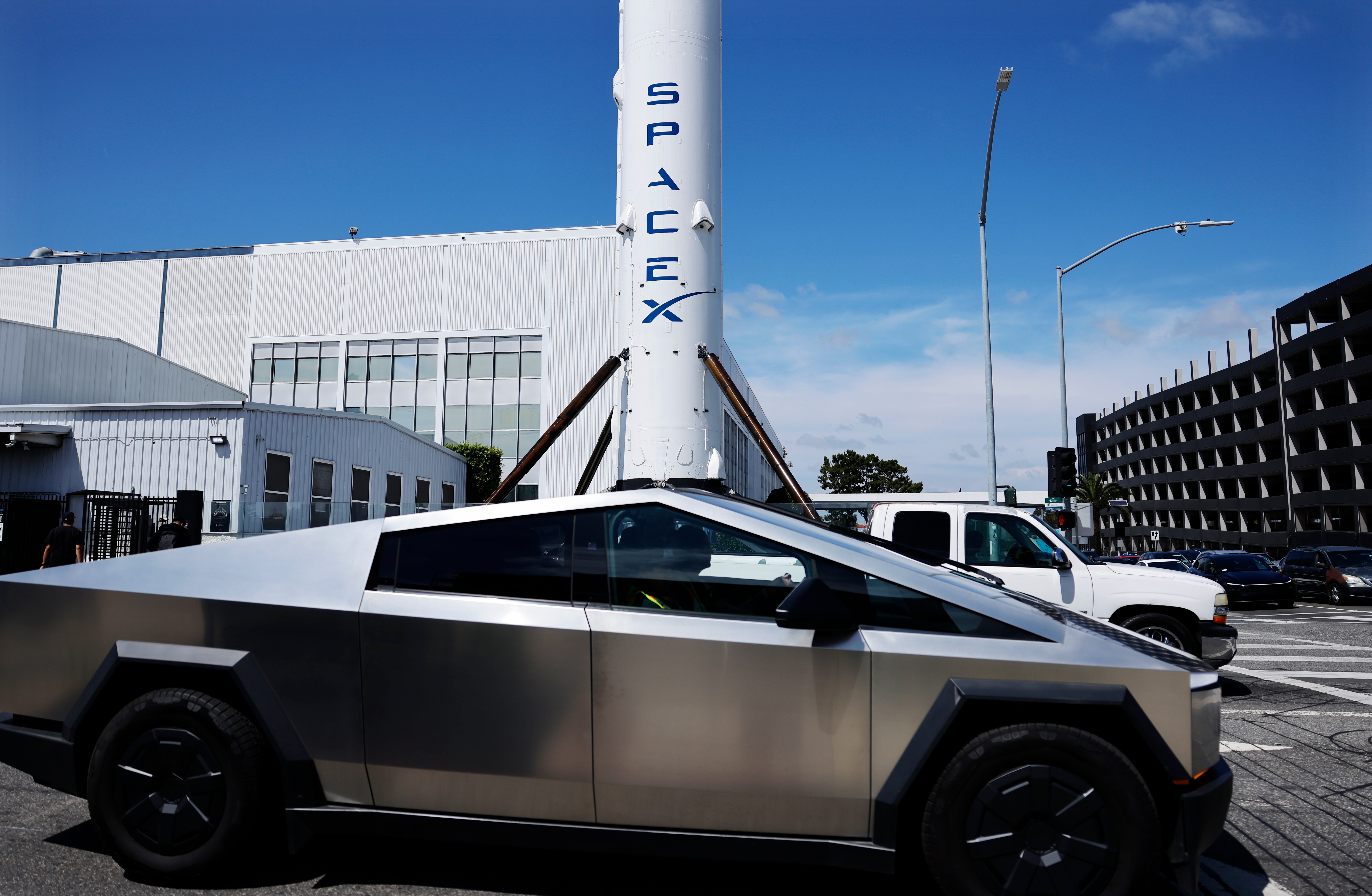<p>Un Tesla Cybertruck pasa junto a un cohete Falcon 9 de SpaceX expuesto en una instalación de la compañía el 2 de abril de 2026 en Hawthorne, California  </p>
