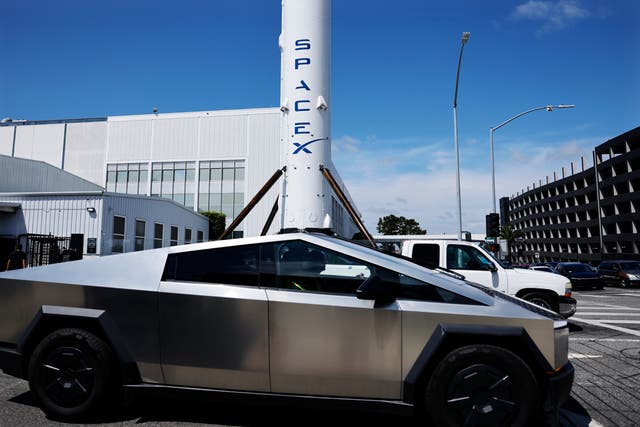 <p>Un Tesla Cybertruck pasa junto a un cohete Falcon 9 de SpaceX expuesto en una instalación de la compañía el 2 de abril de 2026 en Hawthorne, California </p>