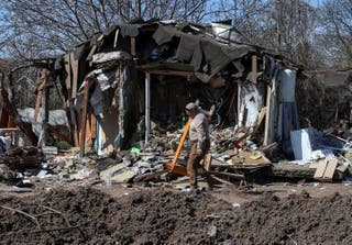 A worker walks at a site of a building hit by a Russian missile and drone strike, in Kyiv, 17 April