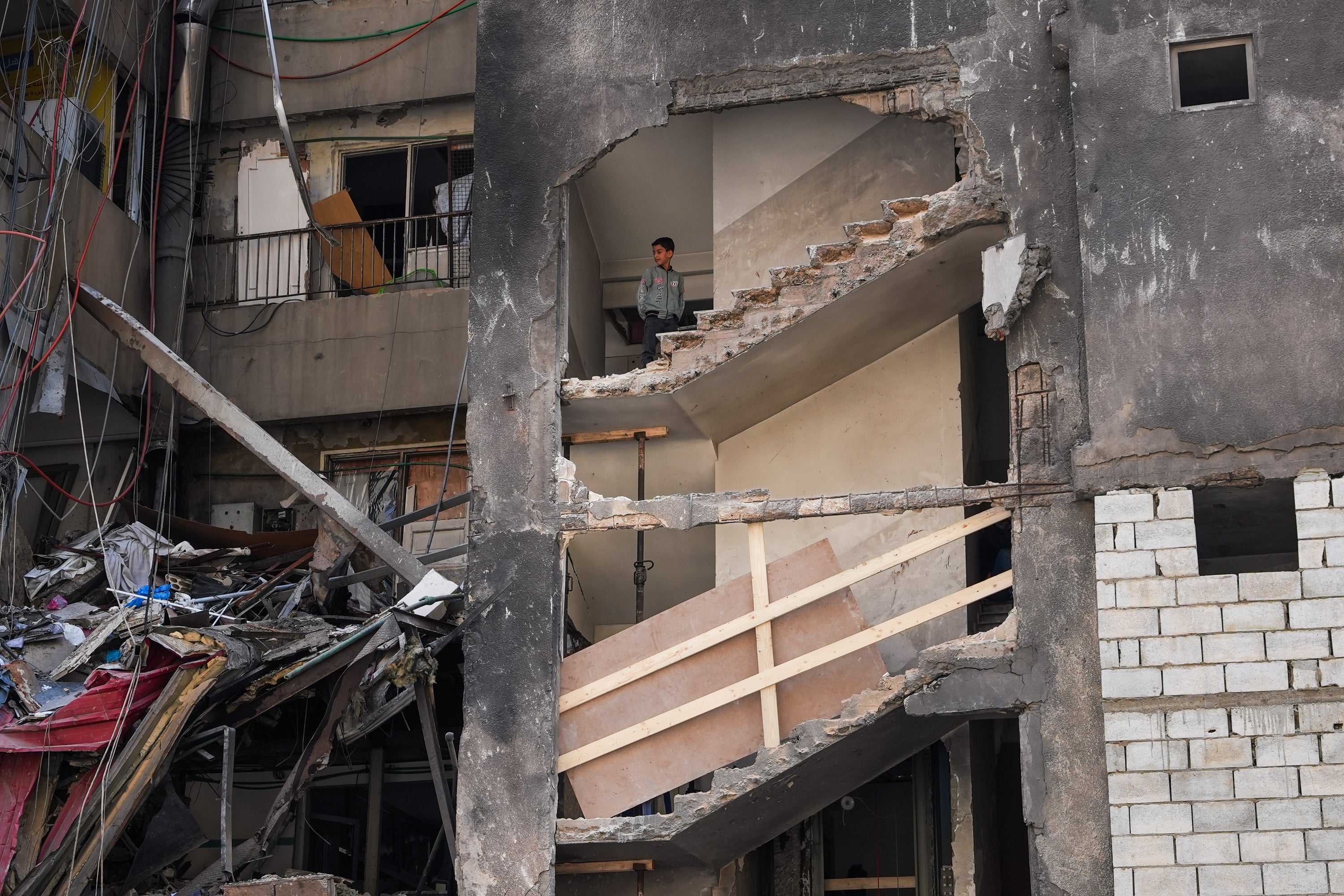 A boy looks on from a residential building that was hit by an Israeli air-strike, on April 17