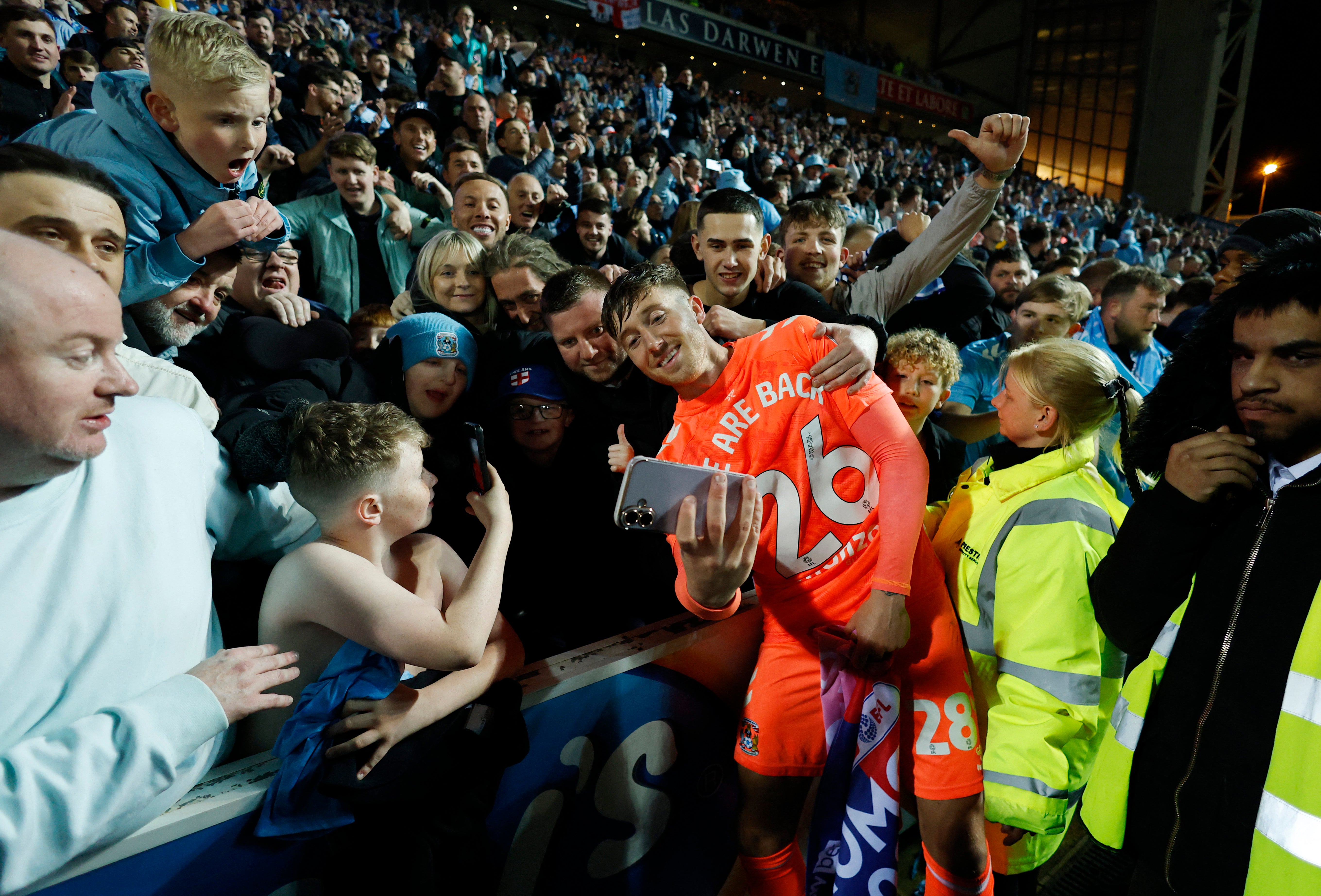 Coventry City's Josh Eccles takes a selfie with fans as they celebrate after winning promotion