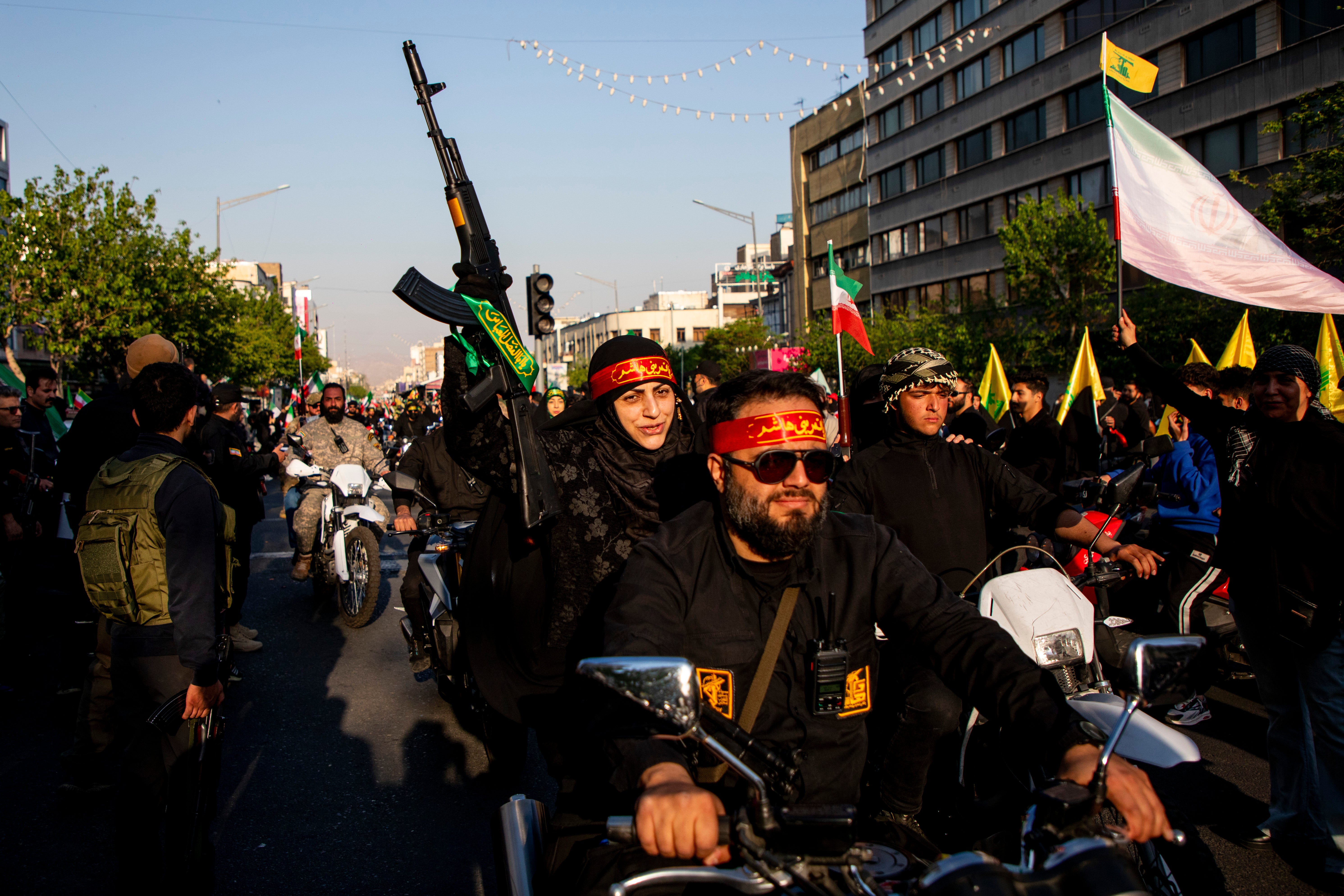 A woman holds a rifle while riding on a motorcycle during a pro-government National Army Day demonstration on April 17