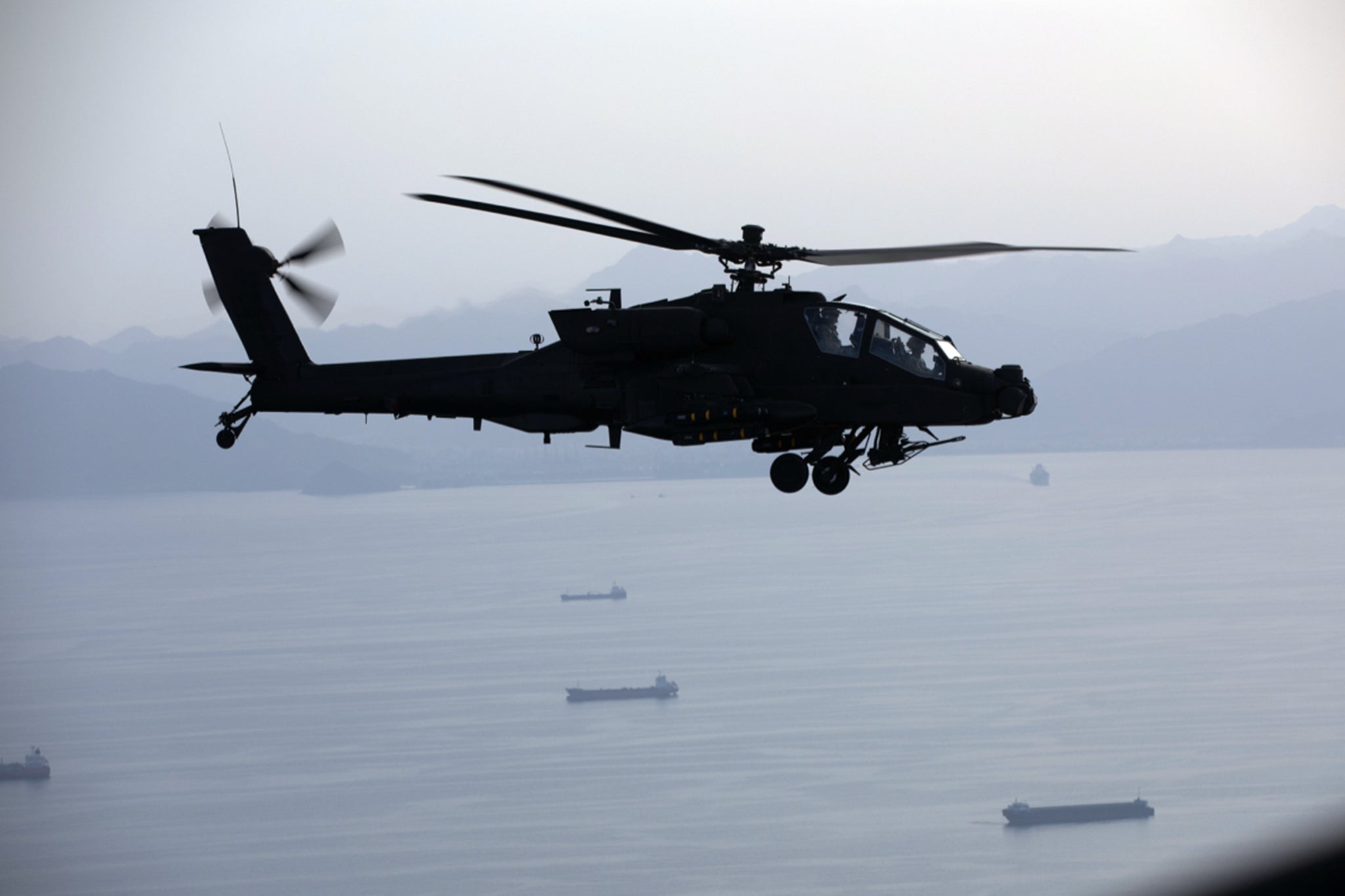 An AH-64 Apache flies above the Strait of Hormuz during a patrol on 17 April 2026