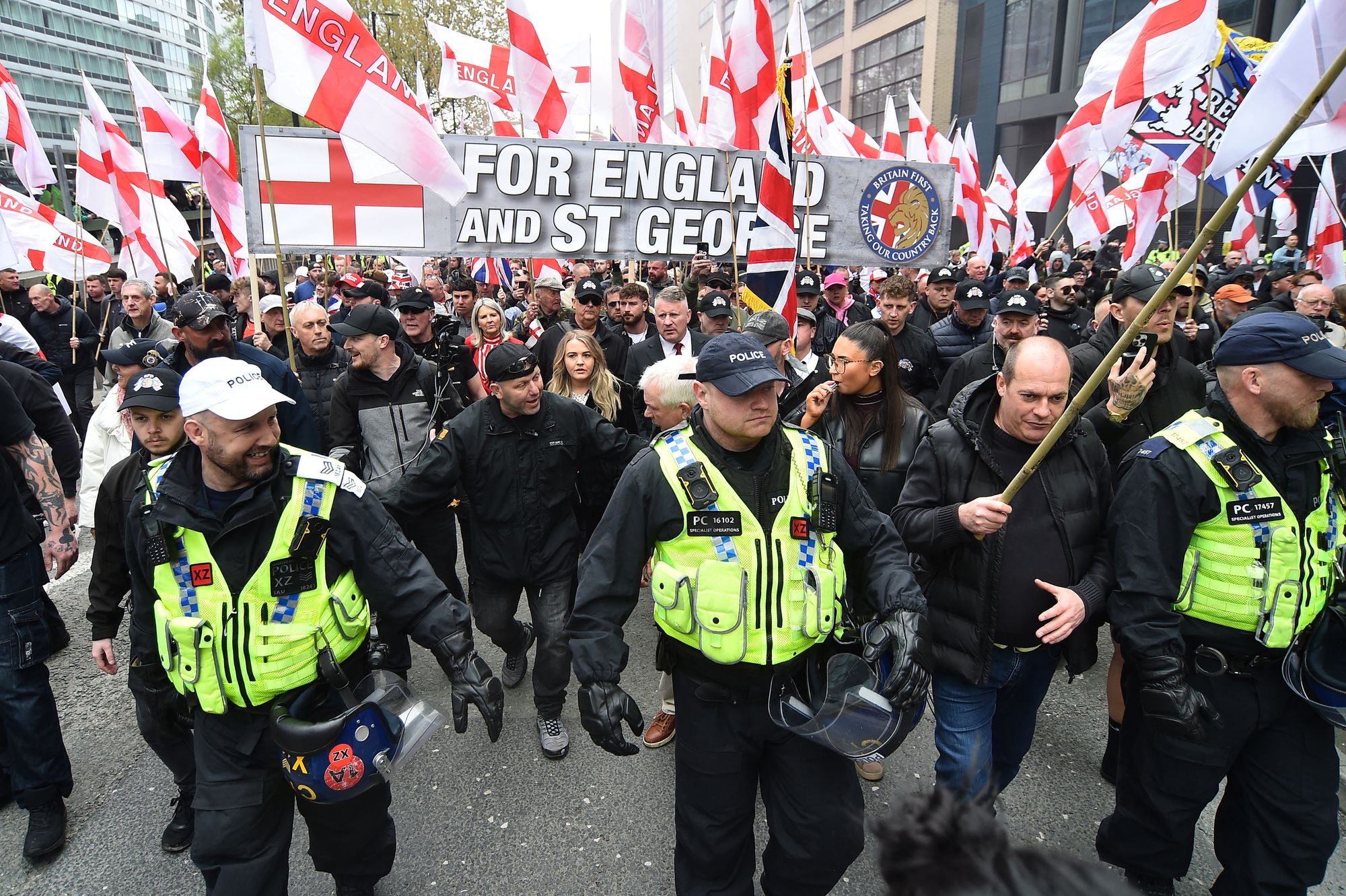 Leader of Britain First, Paul Golding (C) walks alongside people waving Union Jack and St George's cross flags during a Britain First march