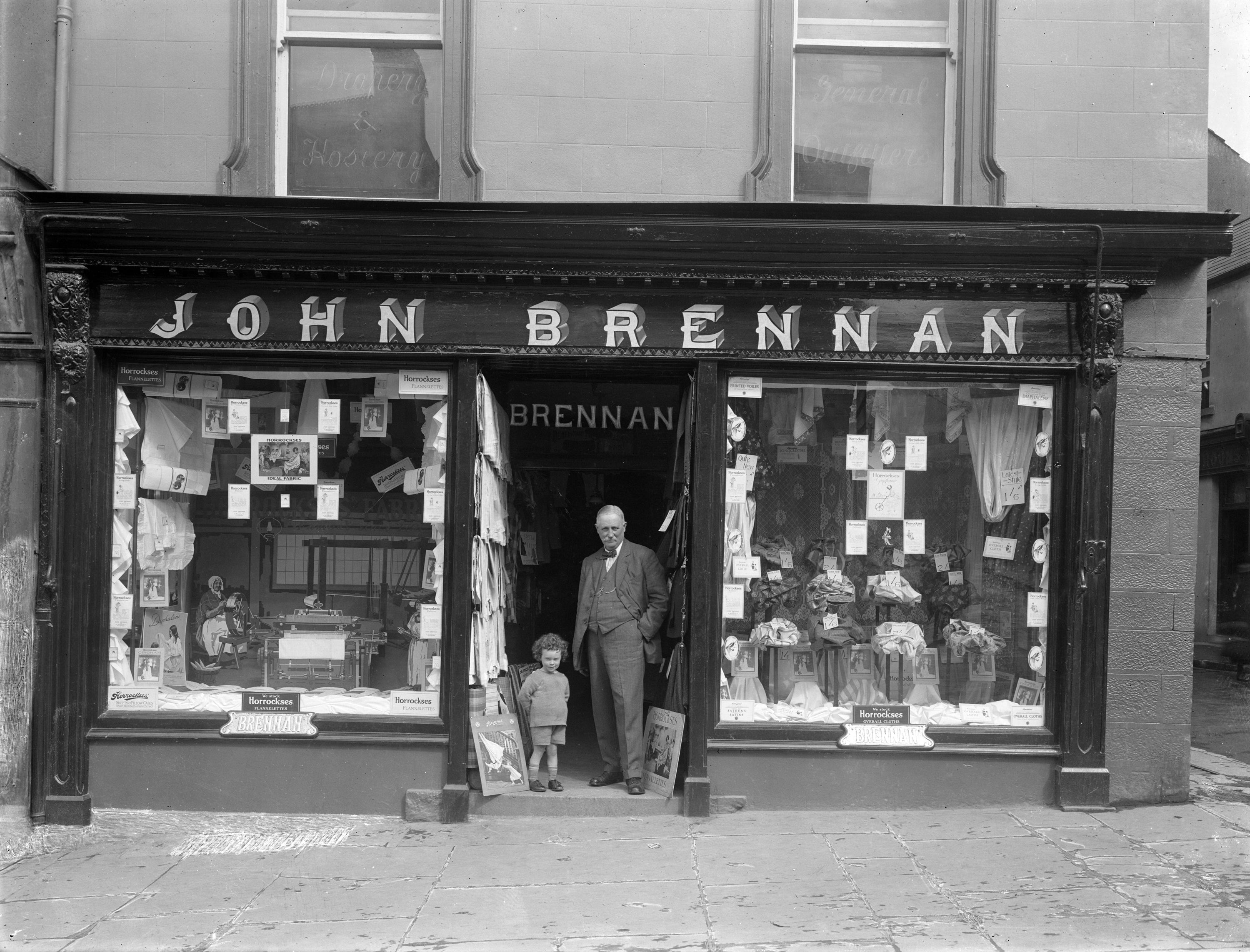 Mr John Brennan with his son, posing in the door of his drapery shop at 27 Barronstrand Street, Waterford, on 10 May 1926