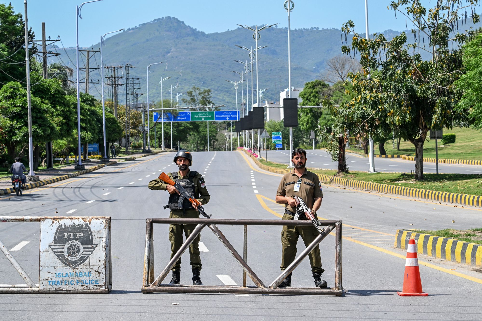 Police personnel stand guard at a closed road leading to the Serena Hotel in the Red Zone area of Islamabad on April 19, 2026. A second round of talks between the United States and Iran is expected in Islamabad this coming week.