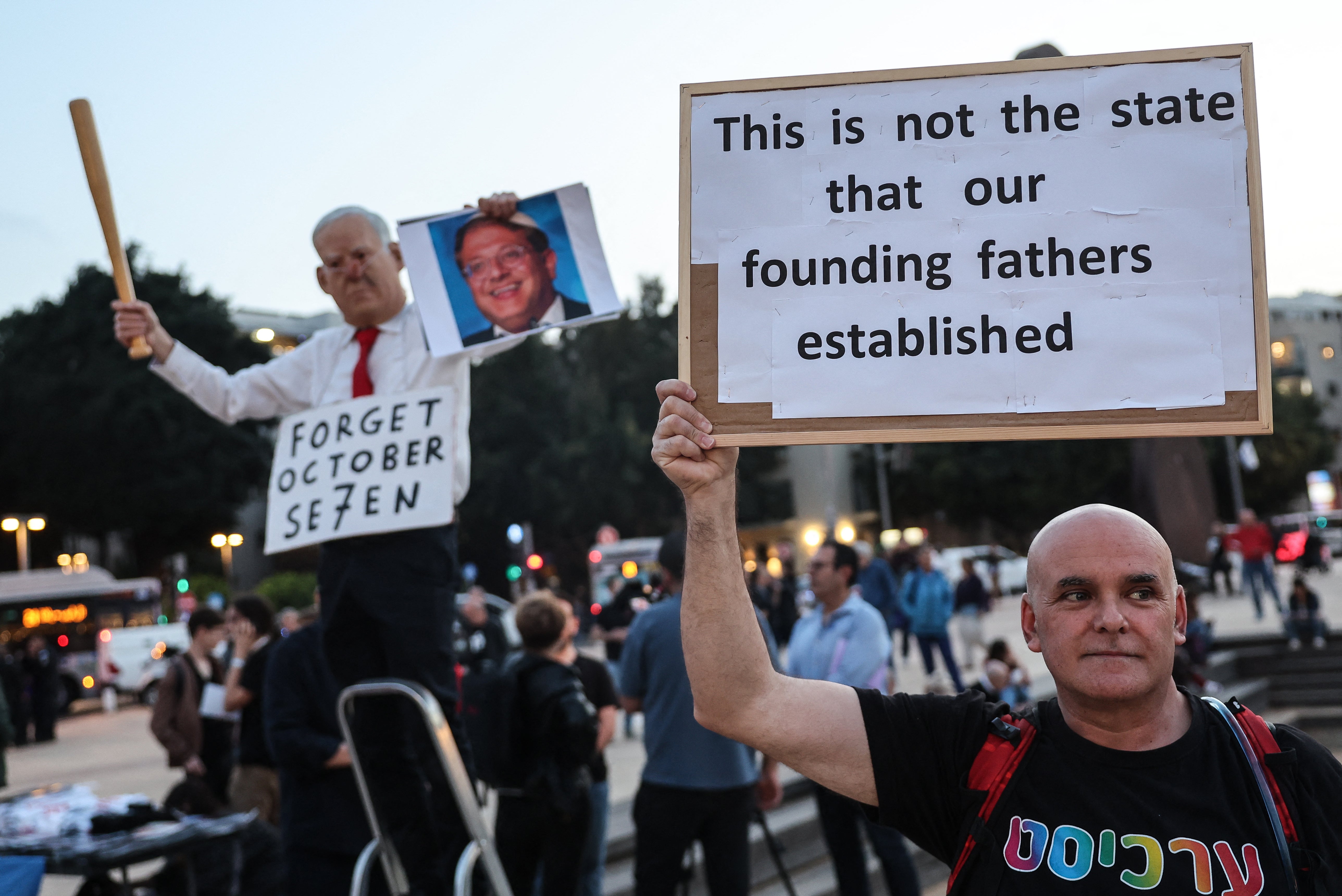 A protester holds up a placard during a demonstration organised by Israeli left-wing activists against the ongoing war with Iran and Lebanon and against the Israeli government, at HaBima Square in Tel Aviv on 18 April 2026