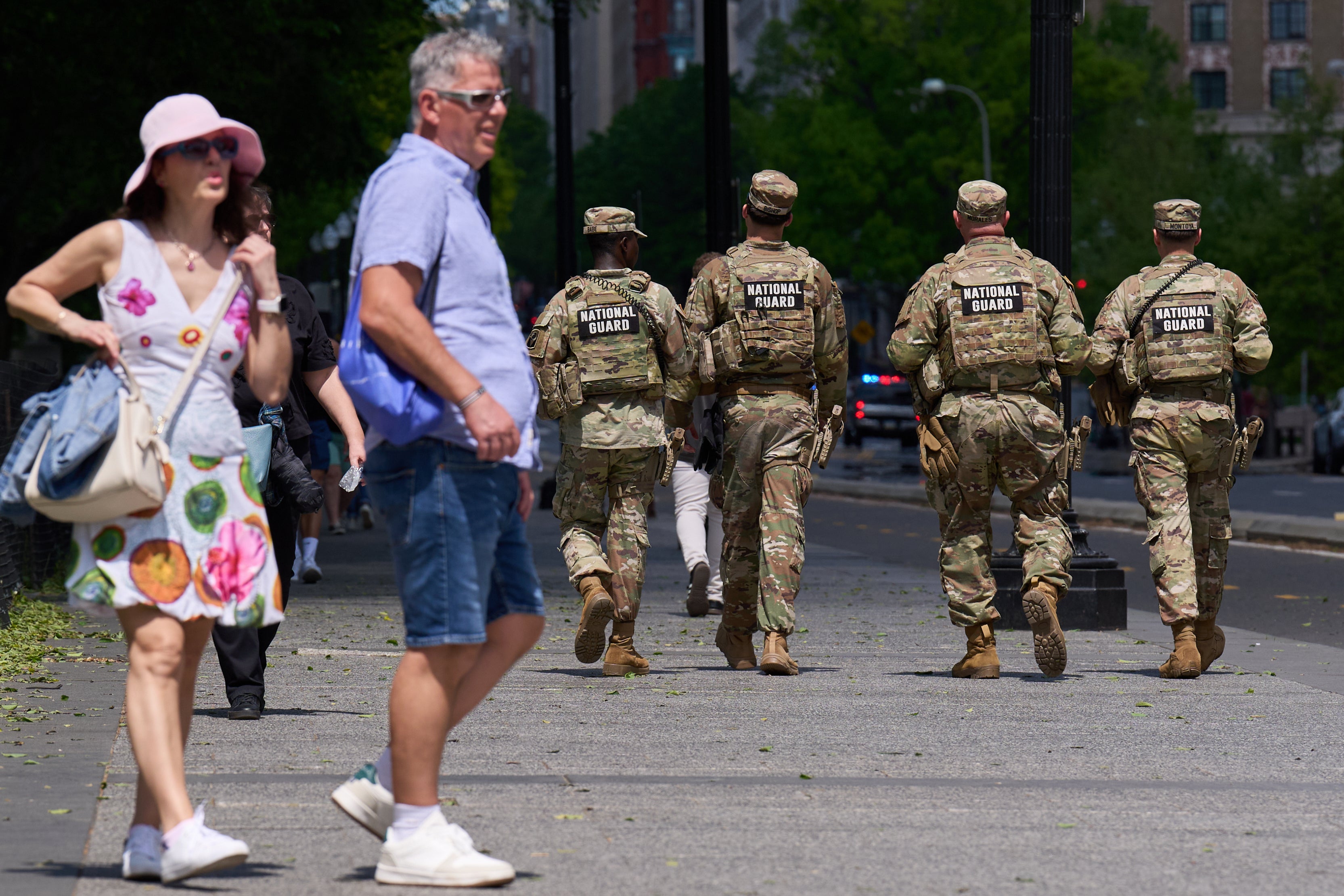Members of the Florida National Guard pass by tourists on a sidewalk Friday, April 17, 2026, in Washington