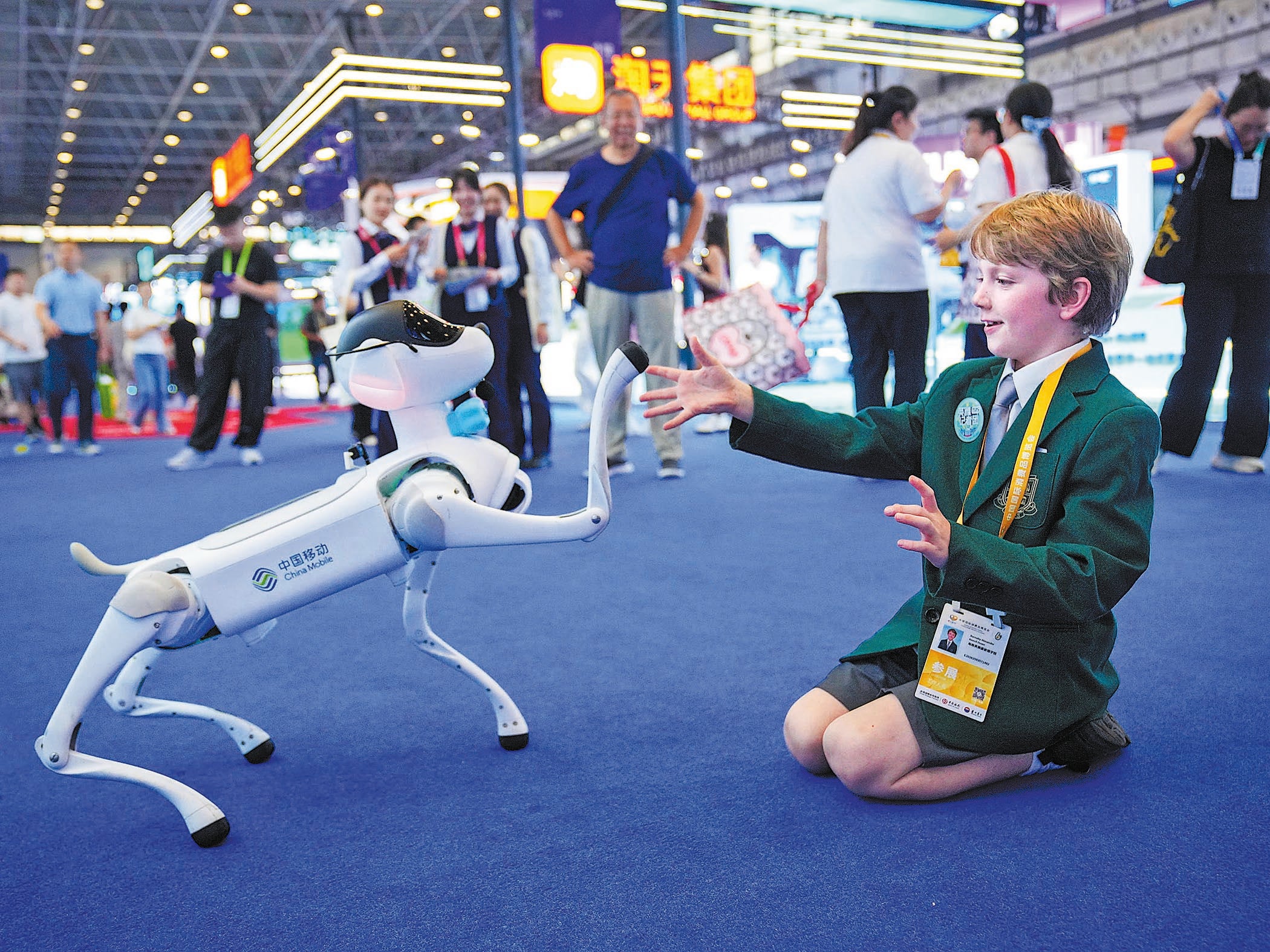 A student from an international school in Haikou interacts with a robotic dog during the expo on 14 April