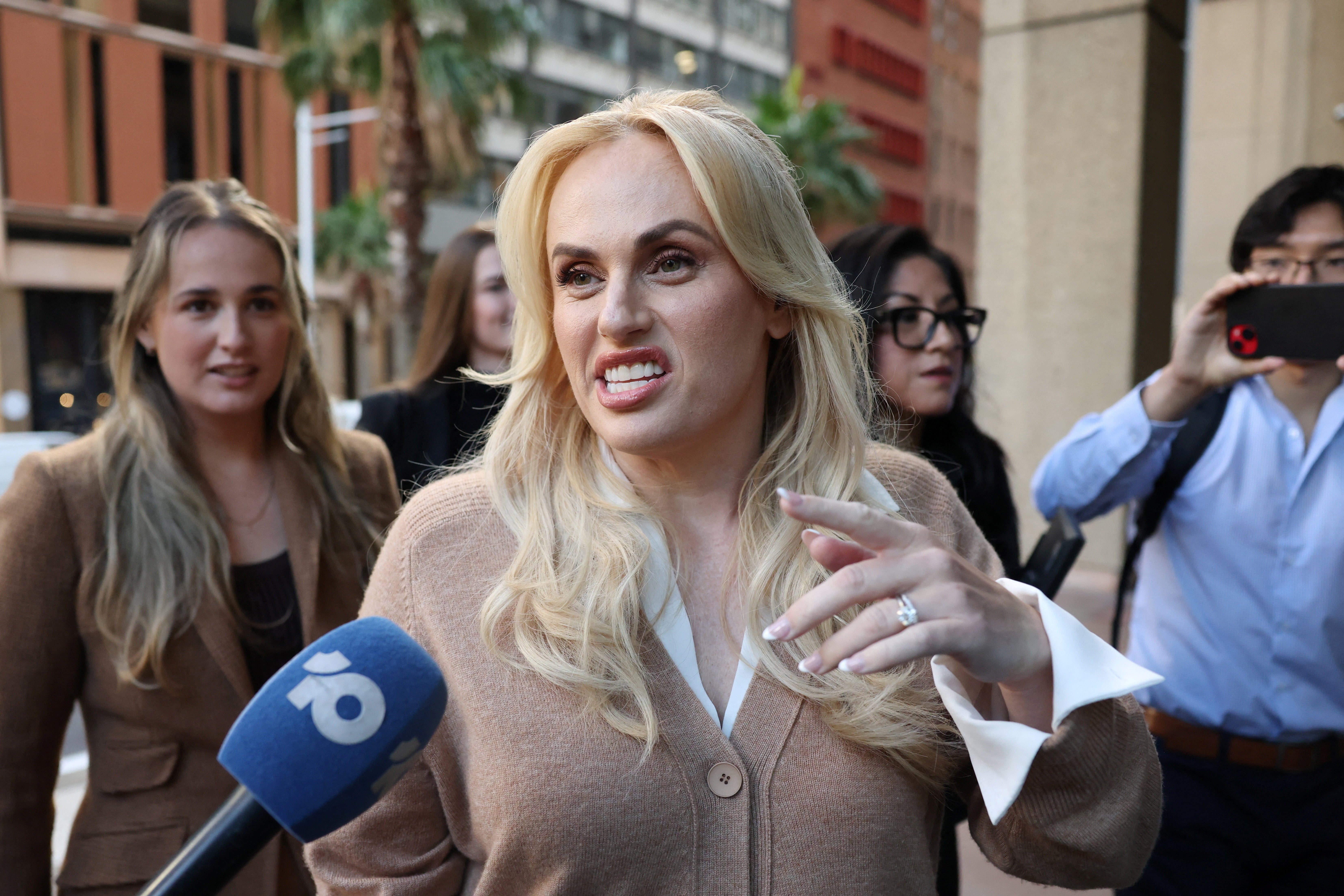 Rebel Wilson speaks to the media as she arrives at court on the first day of a nine-day defamation hearing between Charlotte MacInnes and Rebel Wilson.