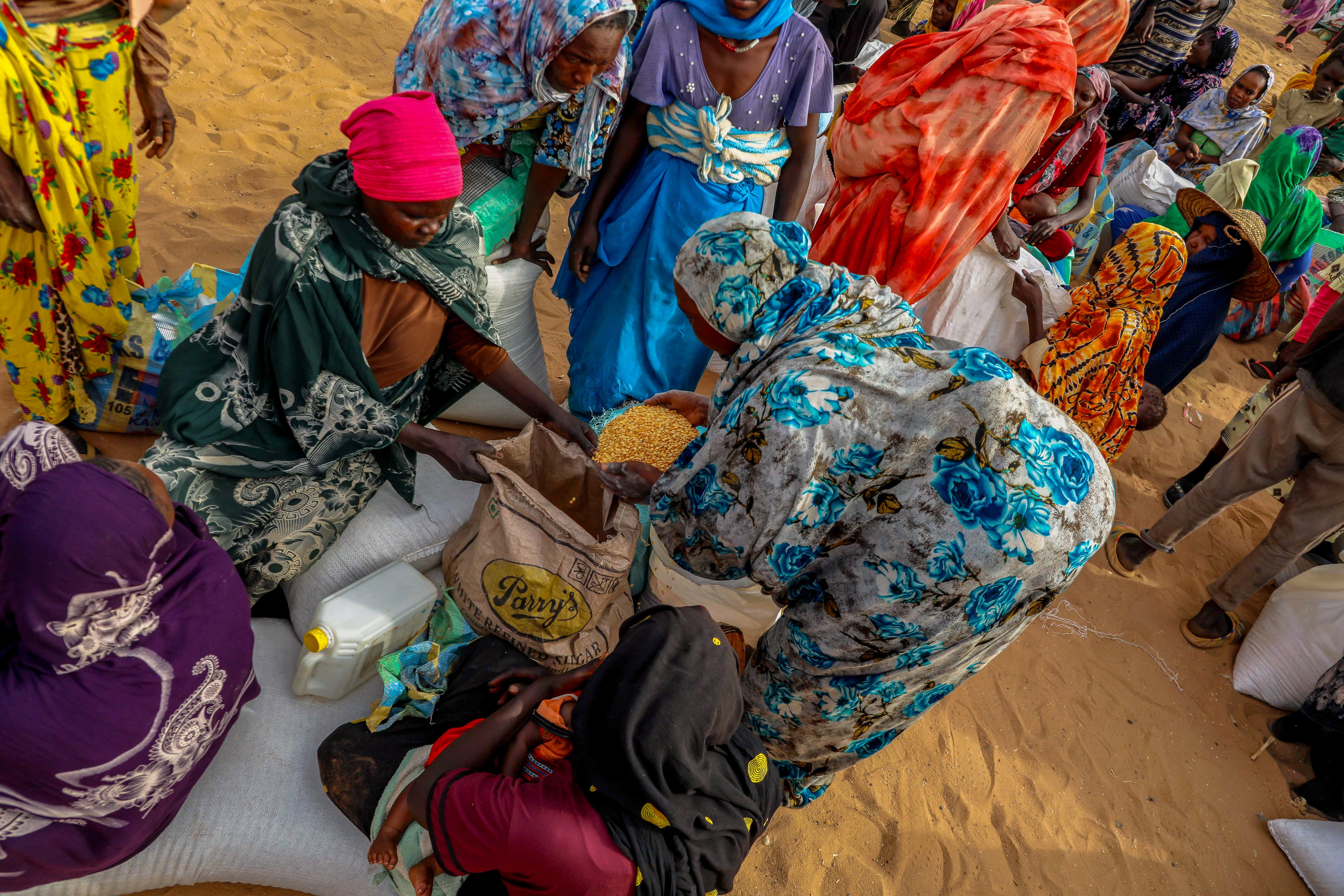 Refugees share the distributed food aid, which includes sorghum, legumes, oil, and salt. in Ouaddai, Chad