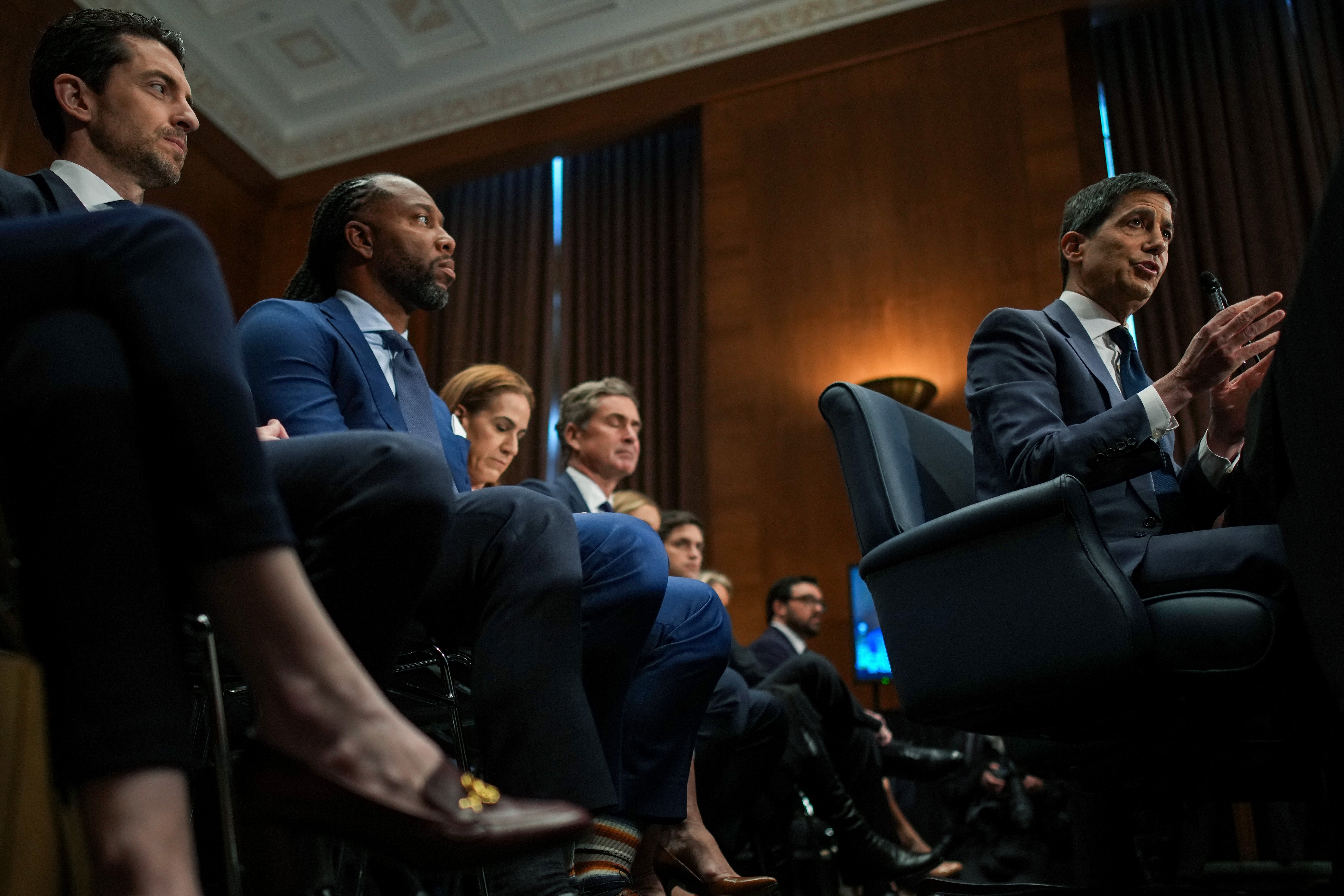 Kevin Warsh. President Donald Trump's nominee for Chair of the Federal Reserve, testifies as former NFL player Larry Fitzgerald Jr. (left) looks on during his Senate Committee on Banking, Housing, and Urban Affairs confirmation hearing in the Dirksen Senate Office Building on April 21