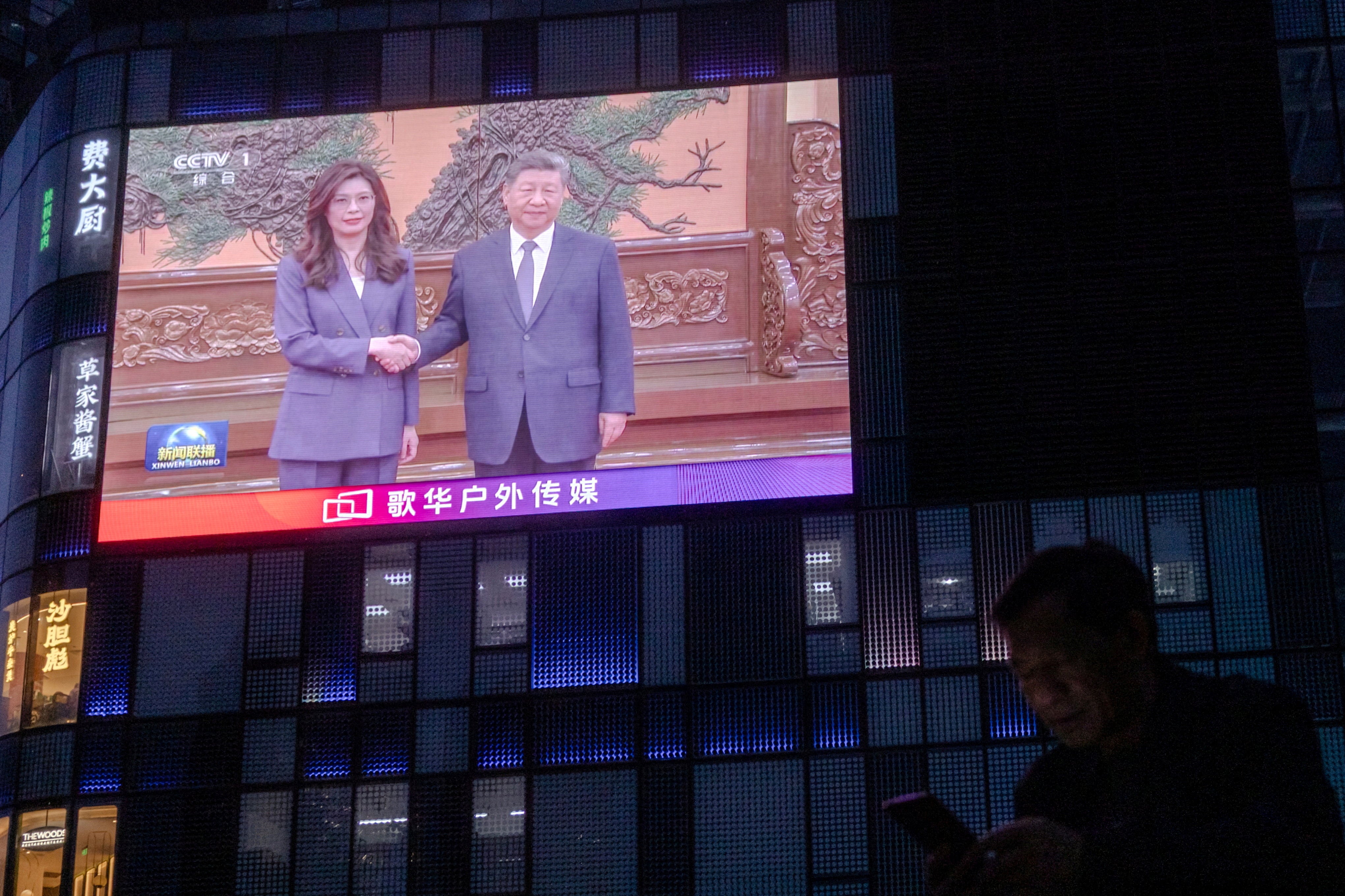 File. A man uses his smartphone as a giant screen broadcasts news showing Chinese president Xi Jinping shaking hands with Cheng Li-wun, chairperson of the Kuomintang (KMT), Taiwan’s largest opposition party at the Great Hall of the People in Beijing, China, 10 April 2026