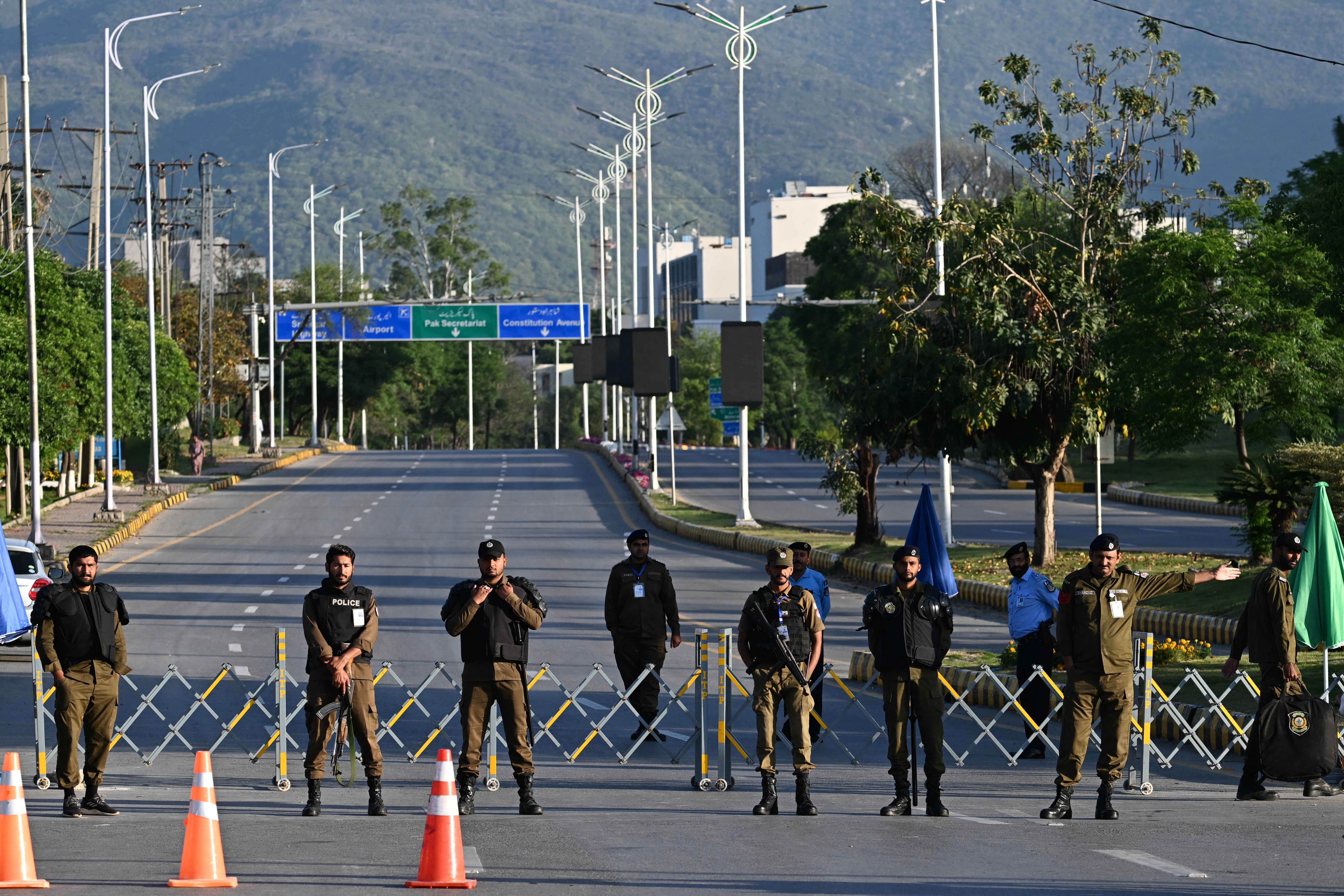 Police officers stand guard at a closed road leading to the Serena Hotel at the Red Zone area in Islamabad on April 22, 2026