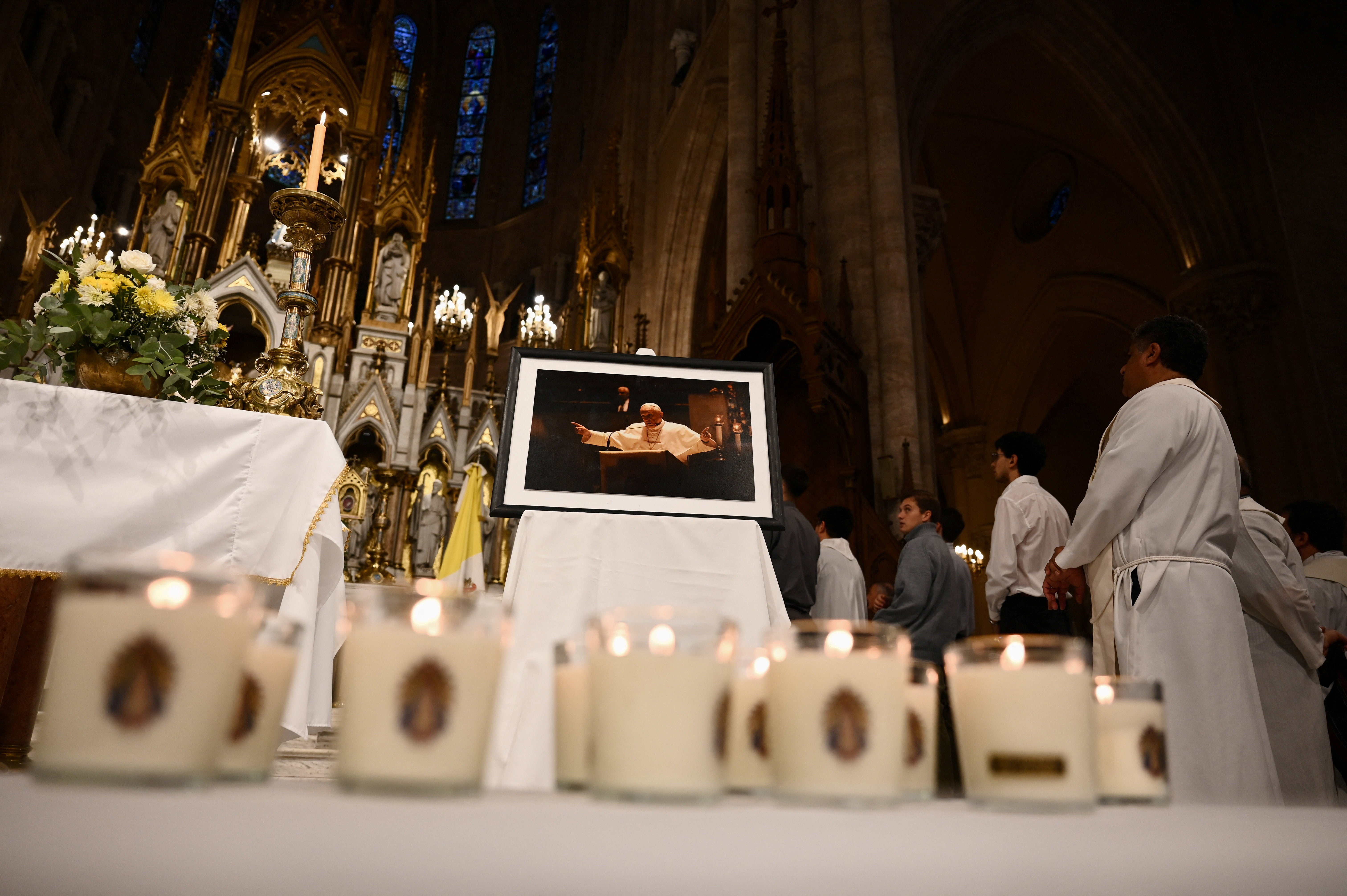 Lit candles lie in front of a portrait of late Pope Francis during a Mass held by Monsignor Marcelo Colombo, the Archbishop of Mendoza, in honour of the late Pope on the first anniversary of his death, in Lujan, Argentina, April 21