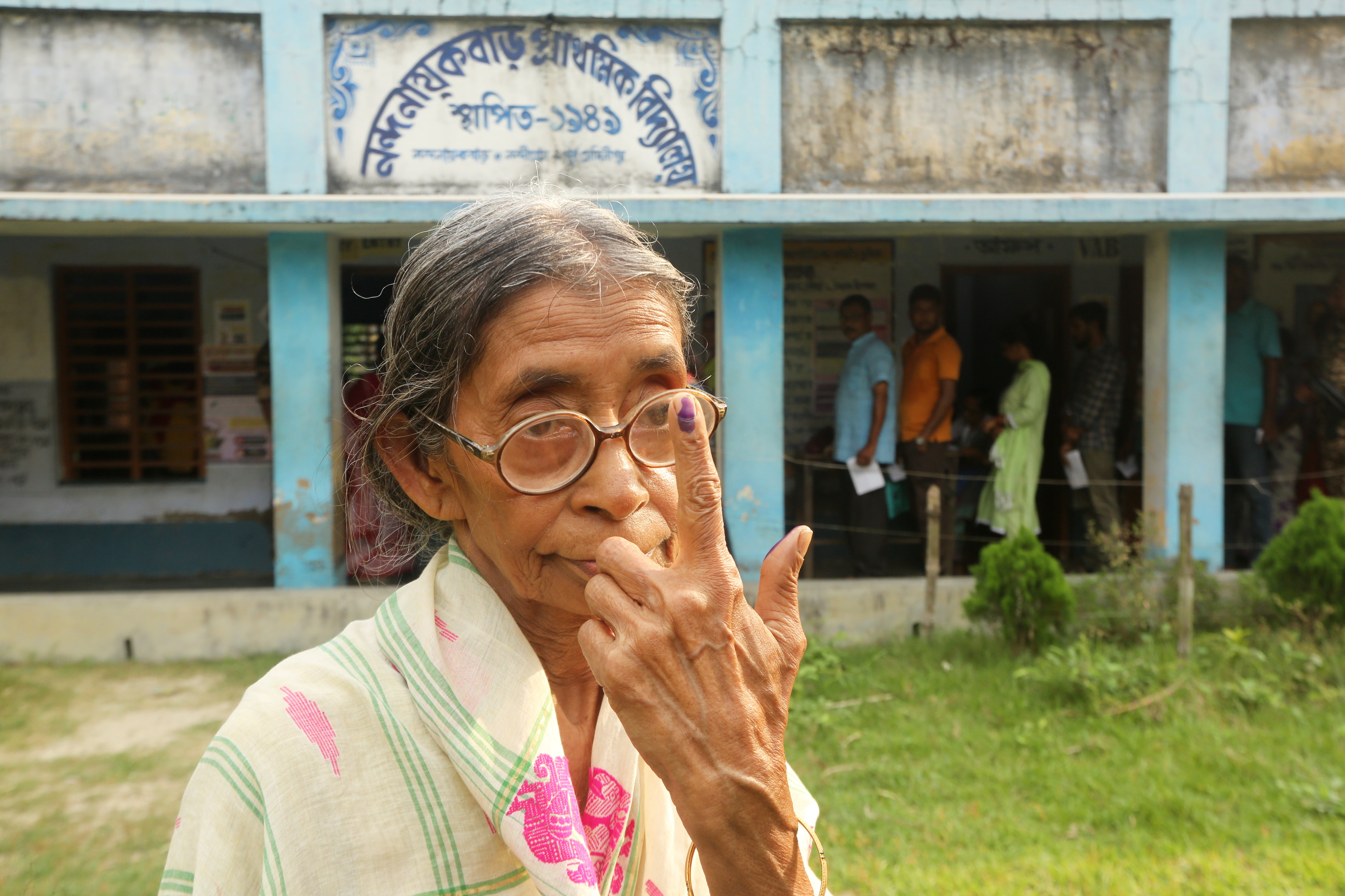 An elderly voter poses for a photograph after casting her vote during the first phase of polling in Nandigram, in West Bengal state, India