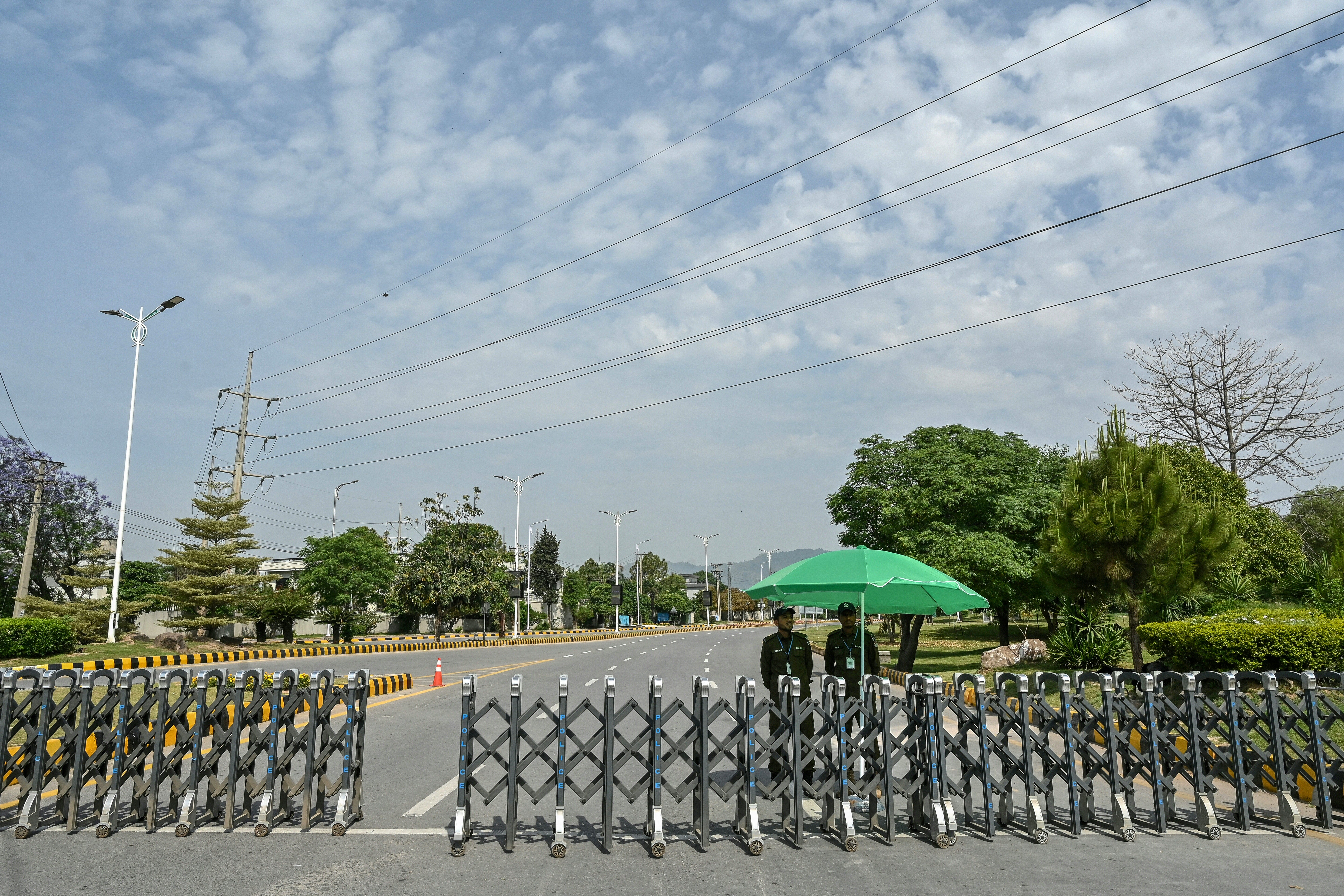 Security personnel stand guard at a closed road leading to the Serena Hotel in the Red Zone area of Islamabad on 23 April 2026. - Pakistan's capital was still locked in gear on 22 April to host high-stakes US-Iran talks that were pushed back at the last minute overnight, but many residents began to tire of the heavy personal and economic toll of tight security restrictions