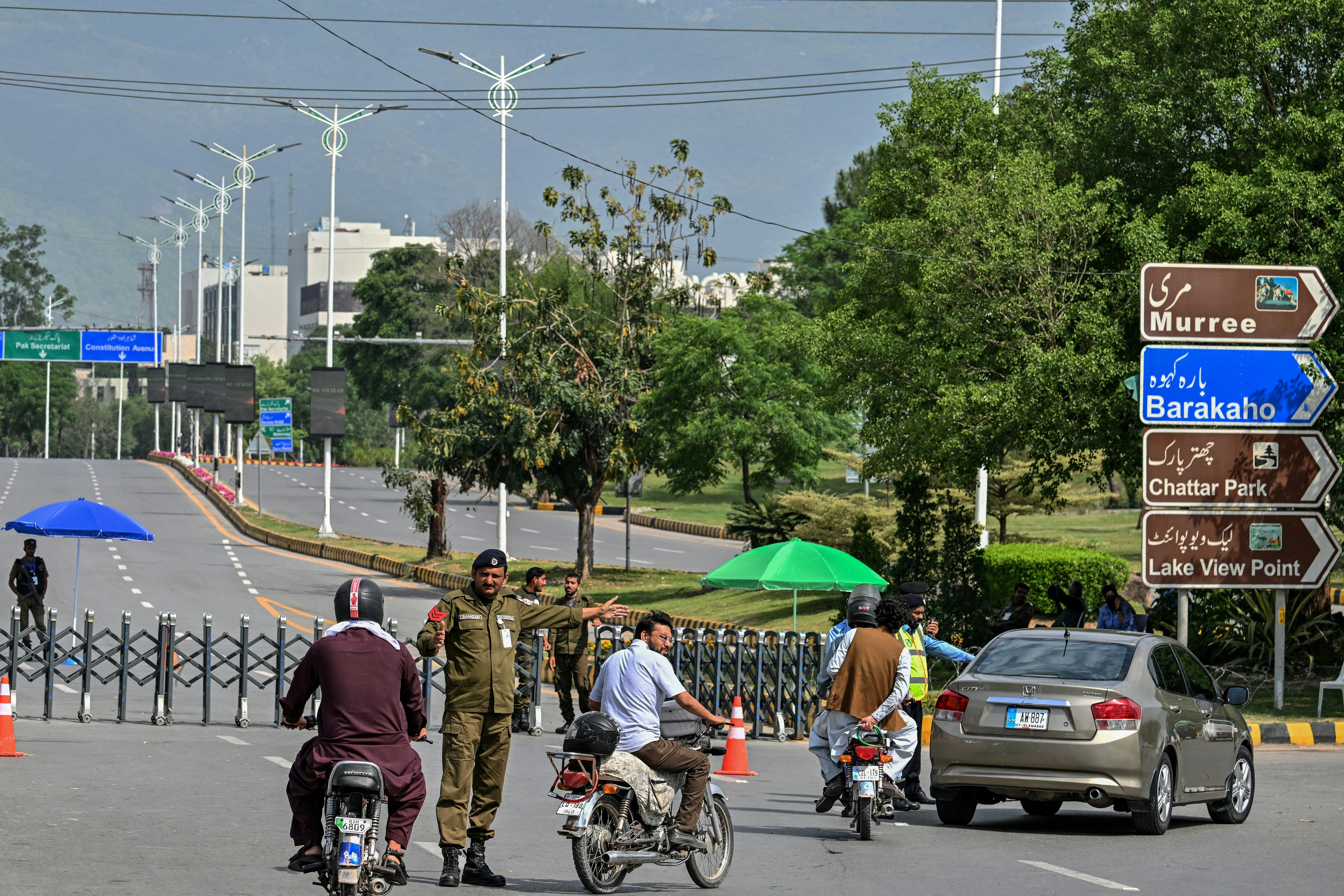 A security personnel manages traffic at a closed road leading to the Serena Hotel in the Red Zone area of Islamabad on 23 April 2026