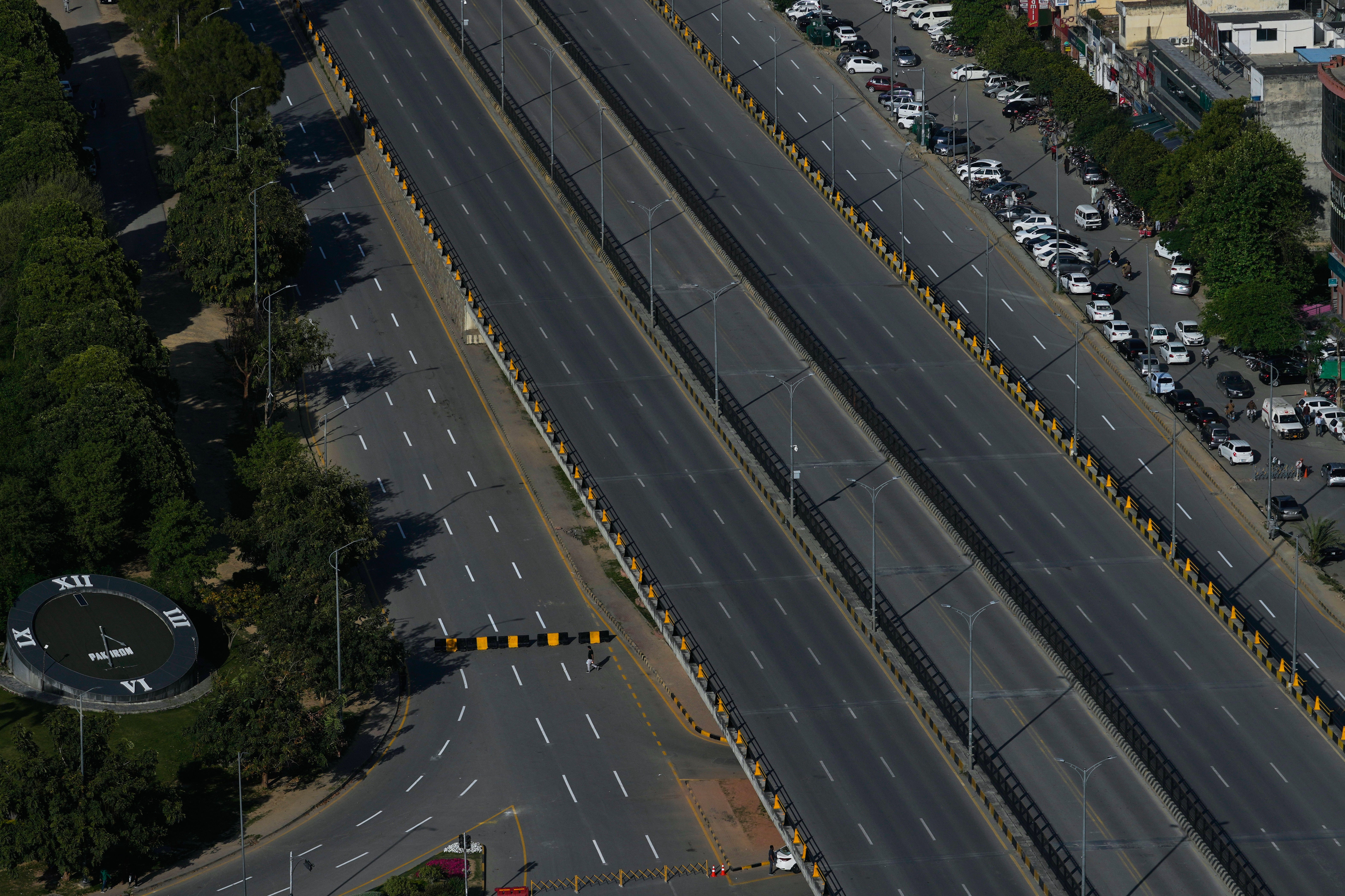 A man crosses a deserted road barricaded by authorities due to security arrangements for the US and Iran talks, in Islamabad, Pakistan, Wednesday, 22 April 2026