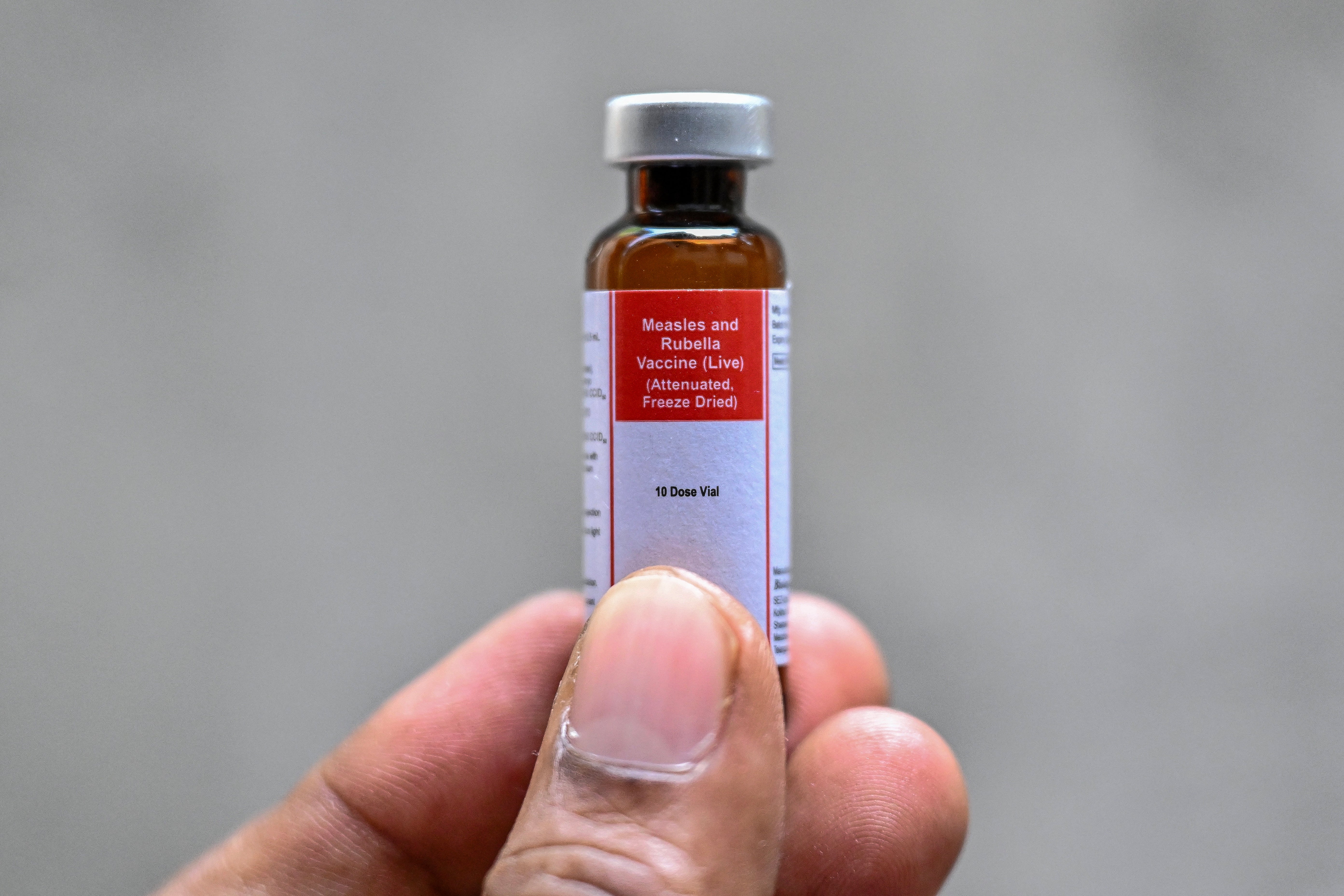 A person holds a vial of measles-rubella vaccine during a vaccination campaign following a recent measles outbreak in Dhaka