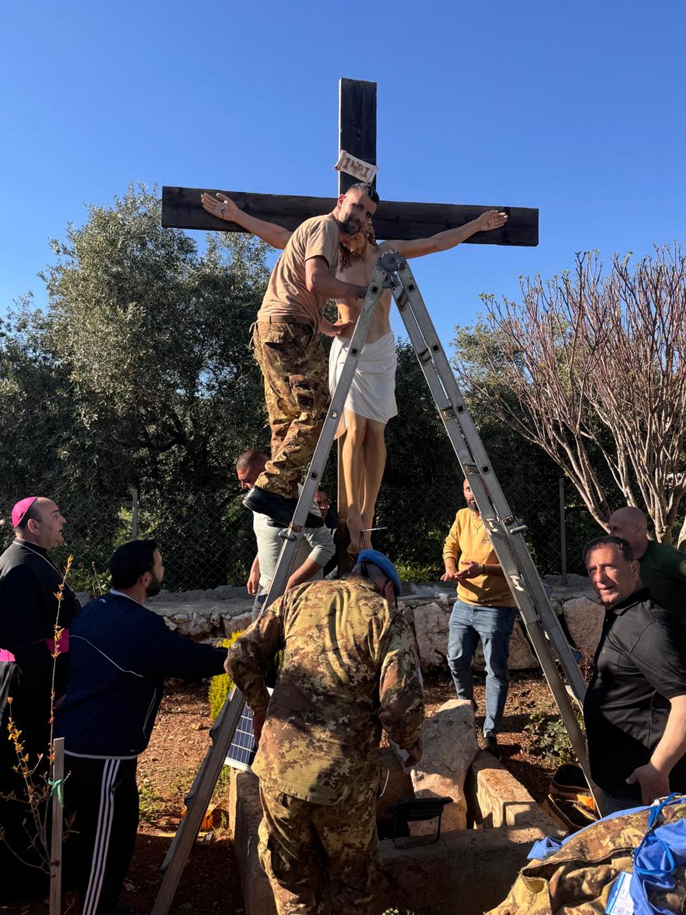 An Italian peacekeeper sets up a crucifix that was sent by Italy to replace one that was defaced last week by an Israeli soldier in the Christian village of Debel, south Lebanon, Wednesday, April 22, 2026. (Hossam Naddaf via AP)