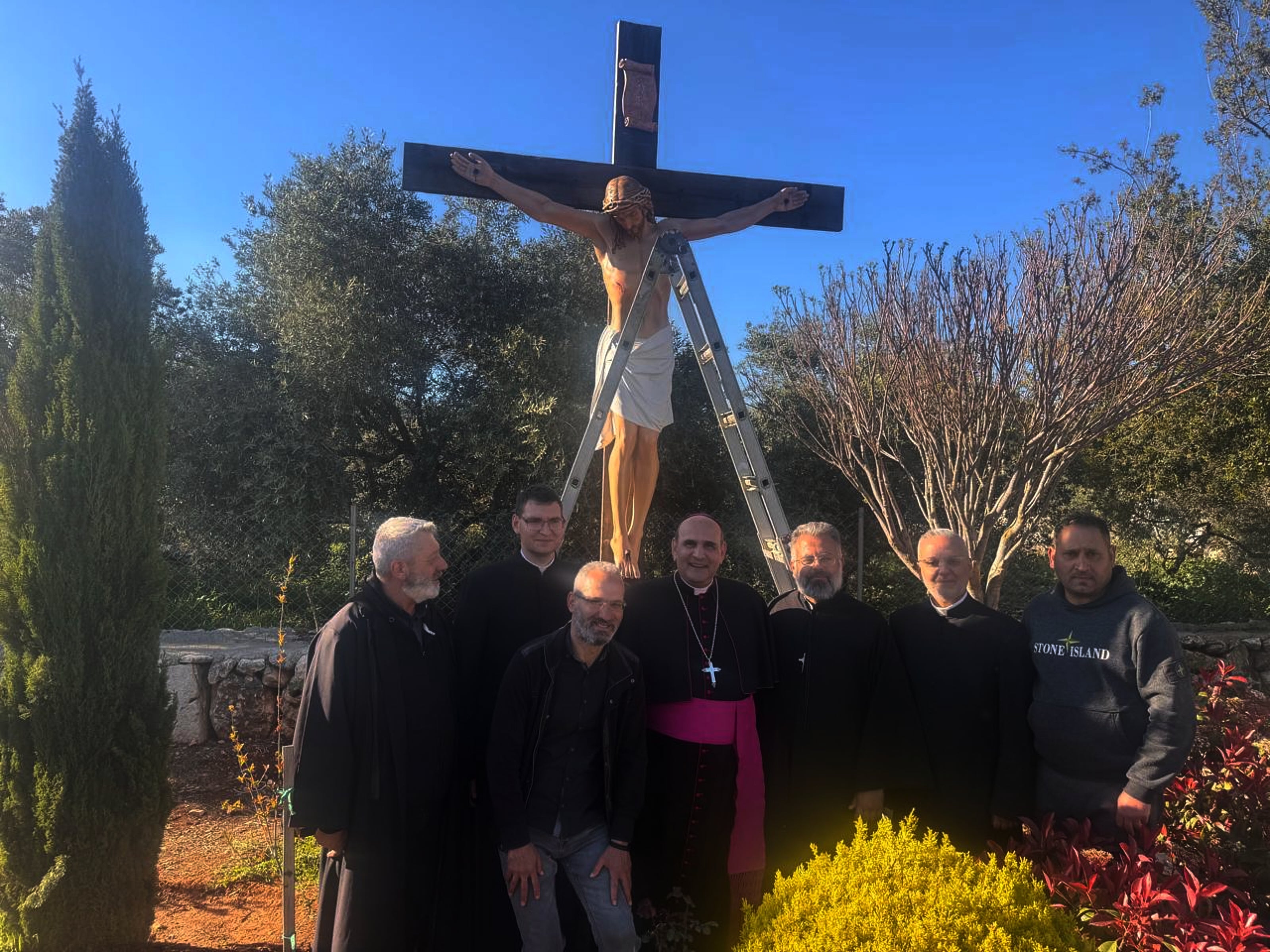 The Apostolic Nuncio to Lebanon Monsignor Paolo Borgia, center, poses with residents next to a crucifix sent by Italy to replace one that was defaced last week by an Israeli soldier in the Christian village of Debel, south Lebanon, Wednesday, April 22, 2026. (Houssam Naddaf via AP)