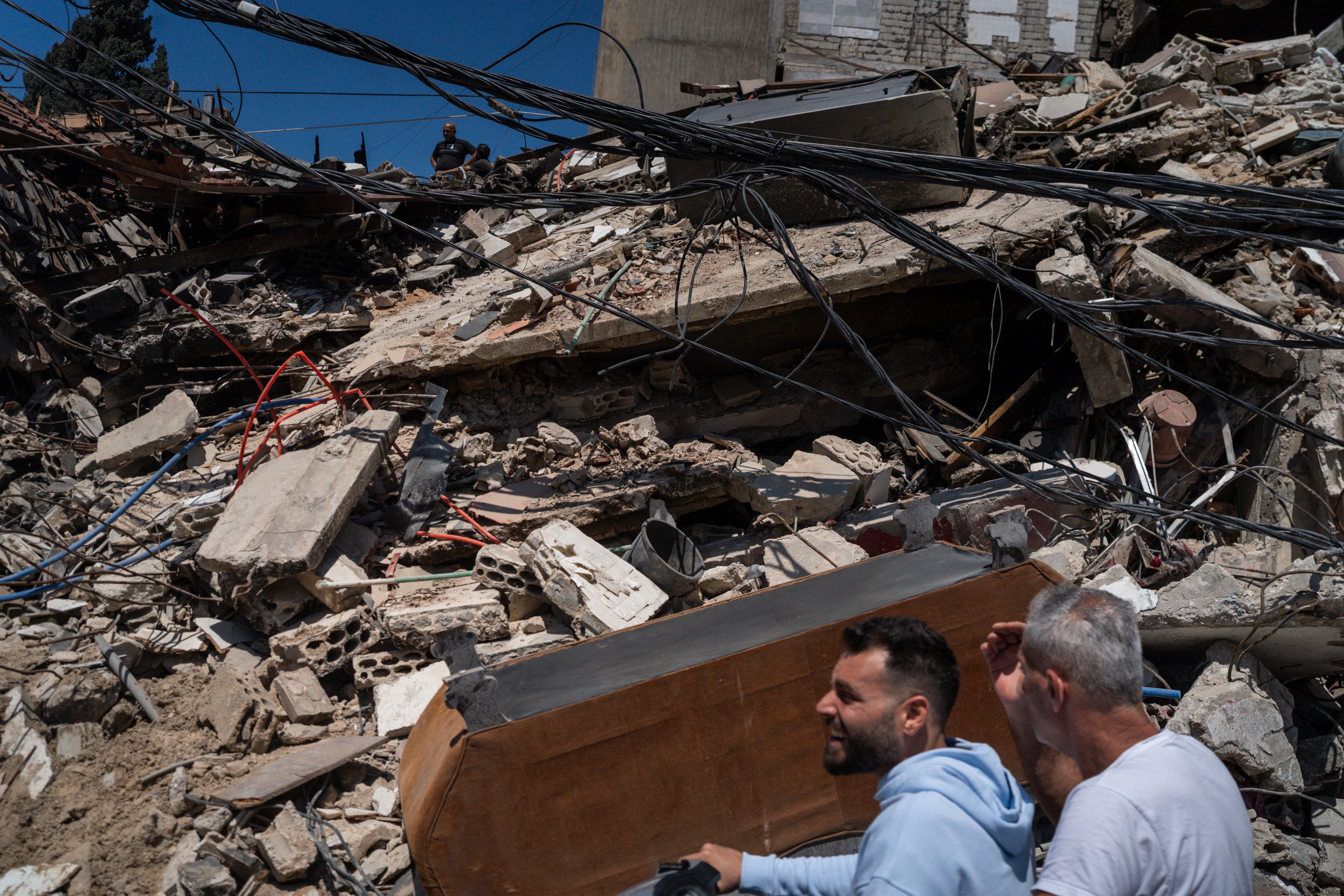 Neighbours on a motorbike checking the aftermath of an israeli airstrike on April 23, 2026 in Tyre, Lebanon
