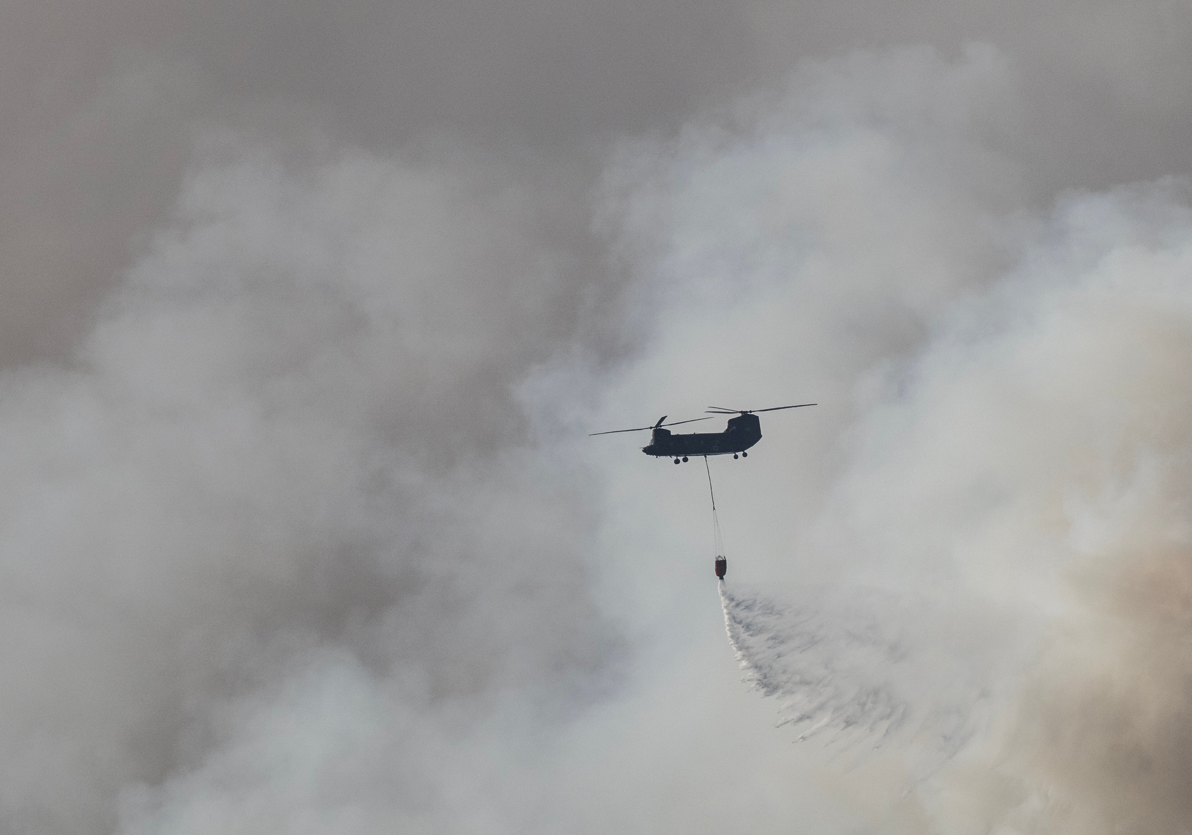 A Japan Self Defense Force helicopter drops water on the head of the fire near the town of Otsuchi in Iwate Prefecture