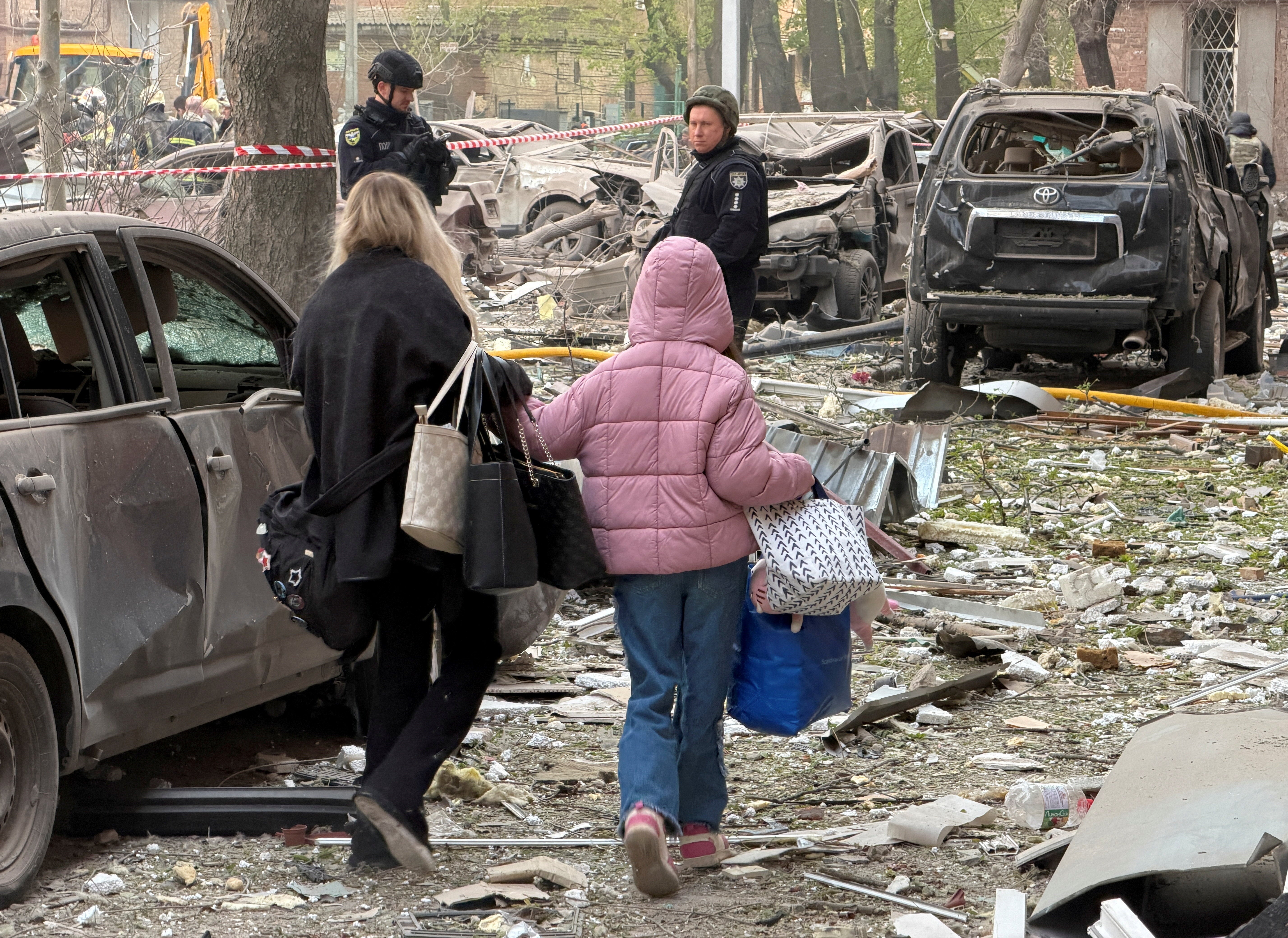 Residents leave the site of an apartment building hit by a Russian drone and missile strike, amid Russia's attack on Ukraine, in Dnipro, Ukraine April 25, 2026.