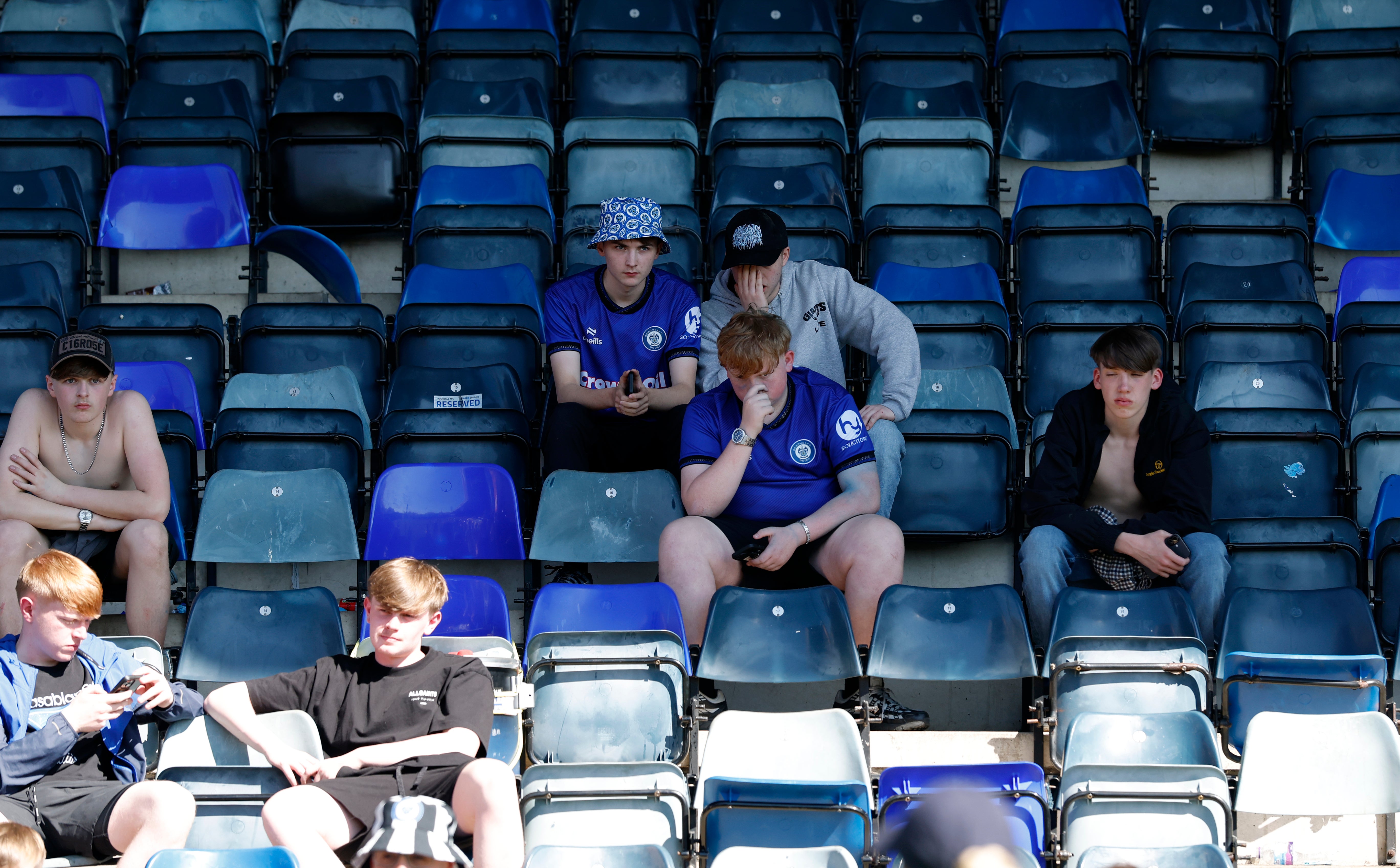 Rochdale fans sit dejected in the stands after missing out on the title