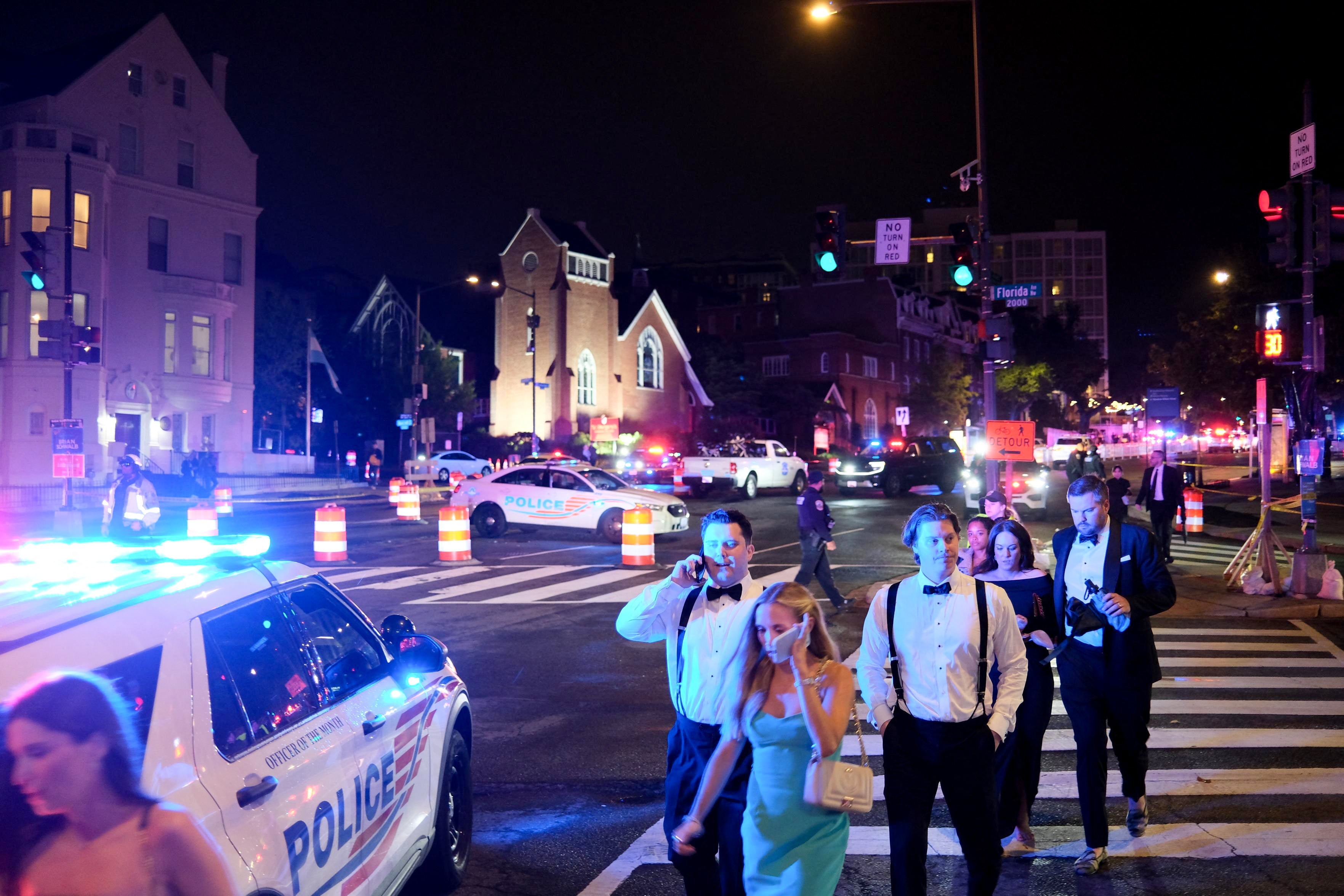 Guests walk away from the Washington Hilton amid a heavy police presence after shots were heard