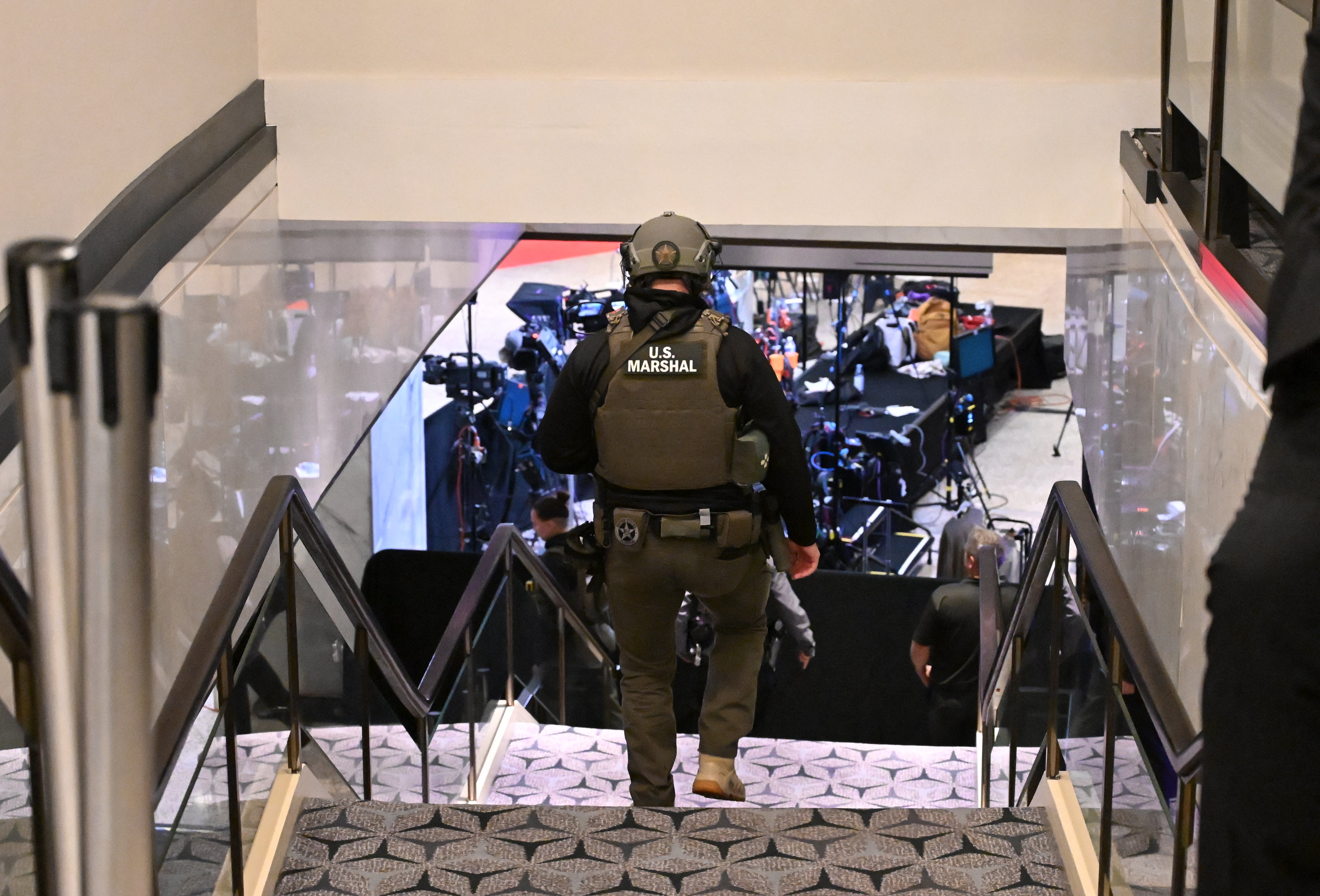 A US Marshall walks through the lobby of the Washington Hilton after shots were heard during the White House Correspondents' Dinner in Washington
