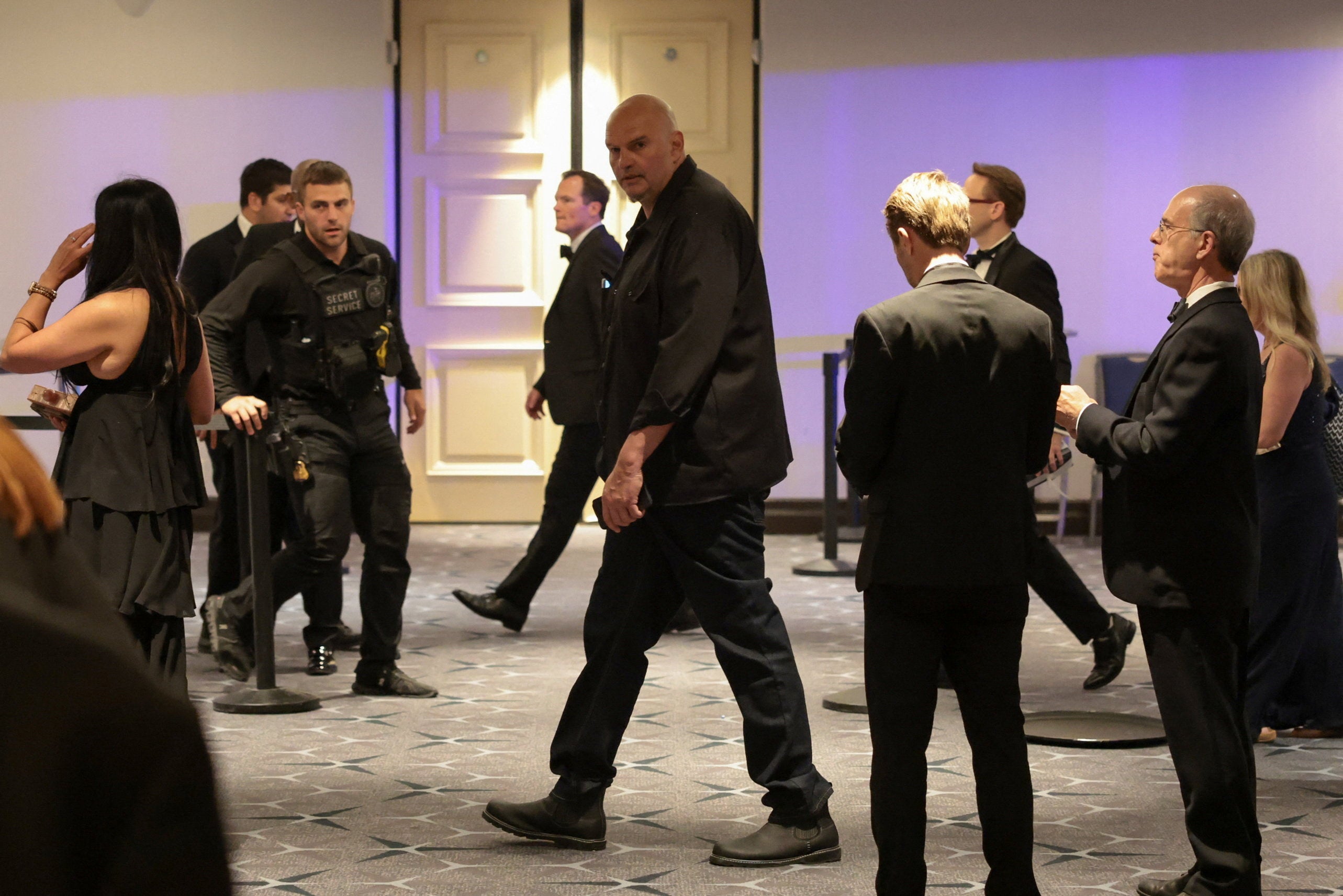 Sen. John Fetterman (D-PA) is escorted through the lobby following the shooting at the annual White House Correspondents’ Association dinner Saturday night