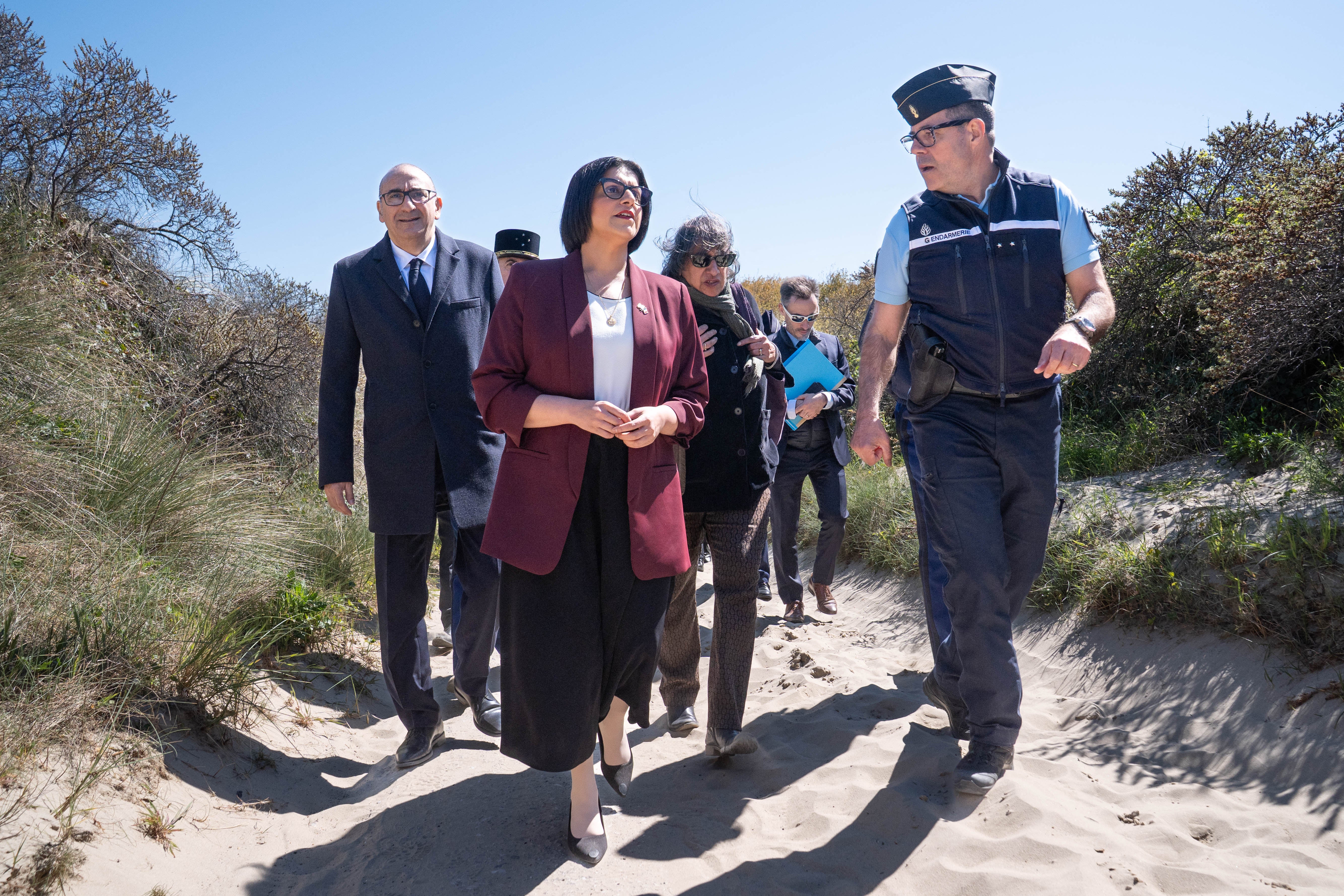 Home Secretary Shabana Mahmood (C) walks with France's Interior Minister Laurent Nunez (L) and French Police officers as they attend a presentation of the operational resources used to counter illegal immigration, on the shores of Zuydcoote, near Dunkirk, on April 23, 2026.