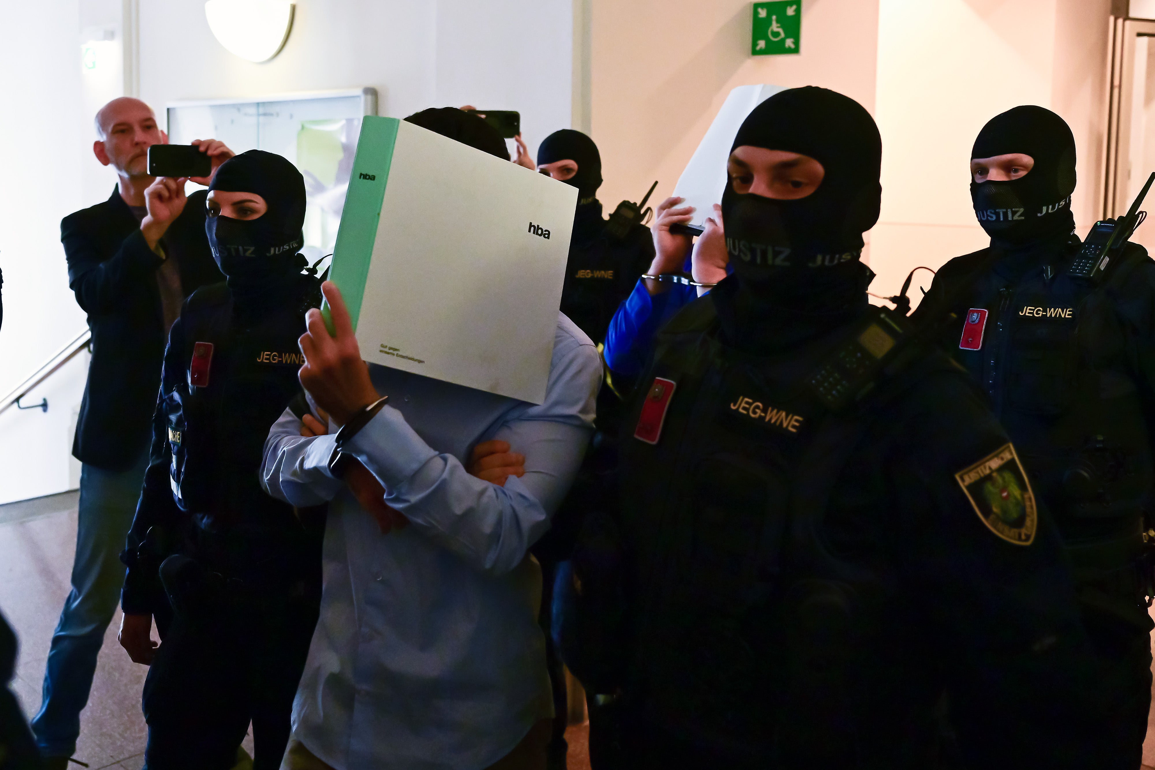 A defendant is led into the hearing room by correctional and police officers on the first day of the Taylor Swift concert plot trial