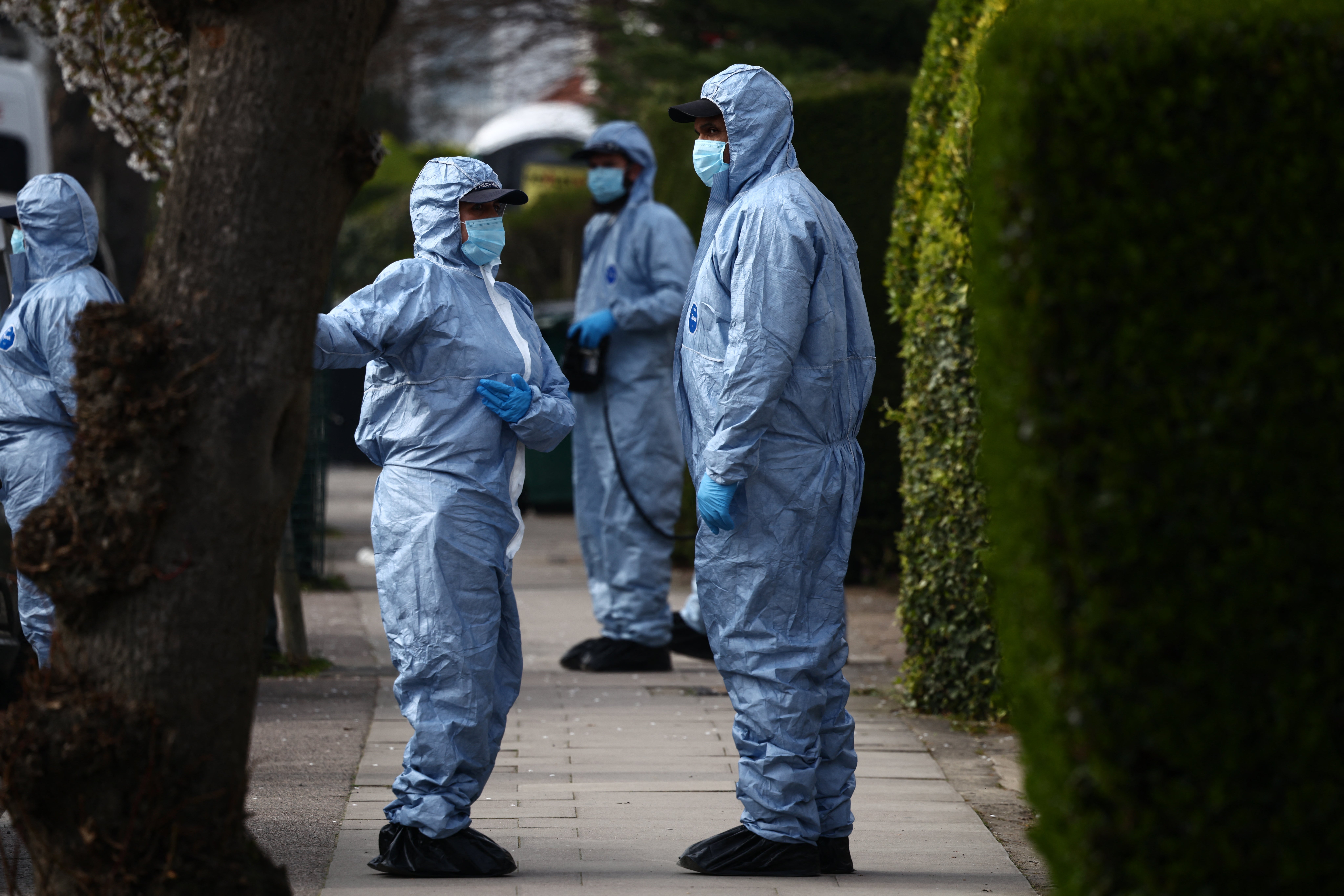 Police forensic officers work outside a house on a street near the incident on March 23, when volunteer ambulances run by a Jewish organization were set on fire.
