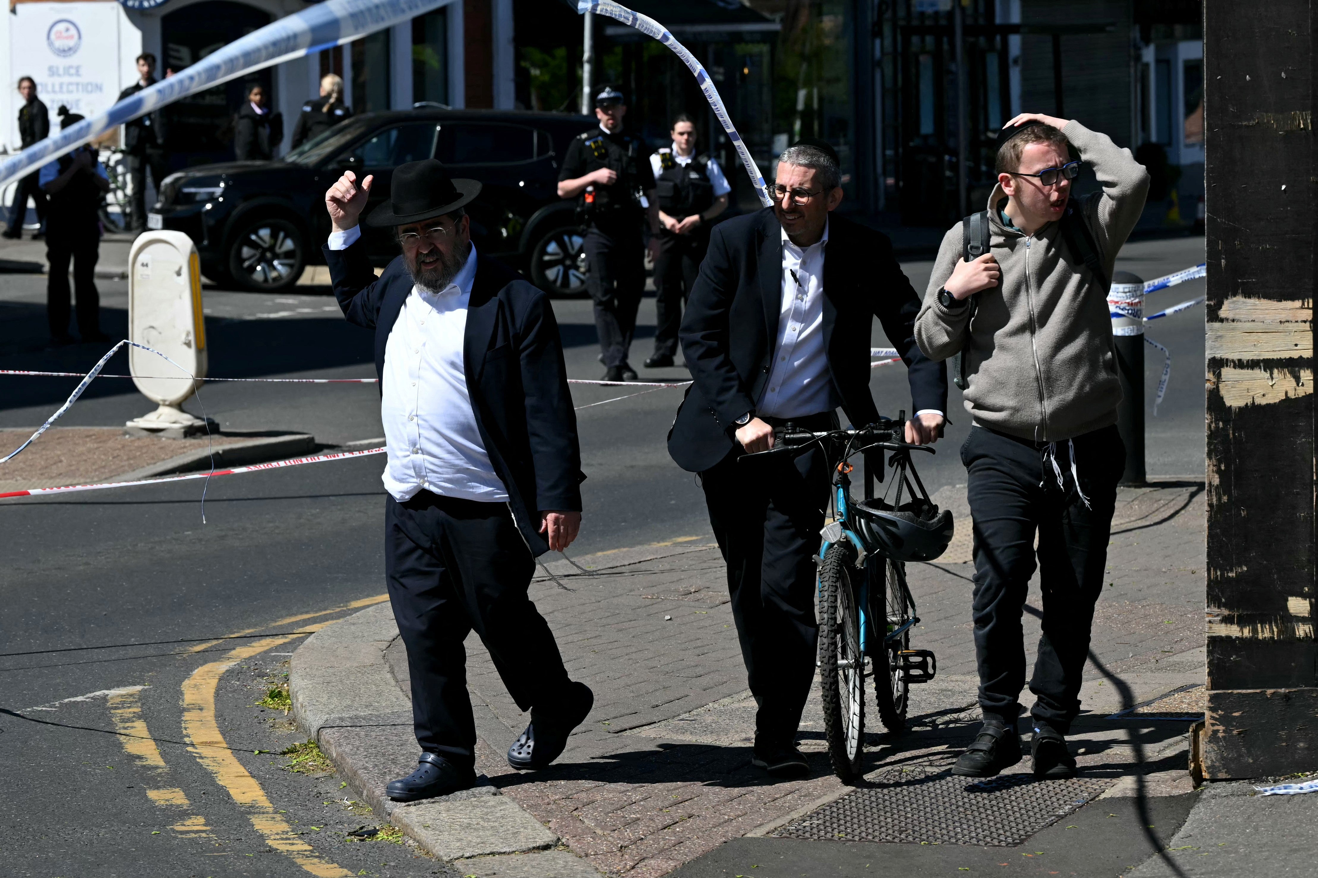 Local residents walk past a cordoned-off area as police investigate the stabbing of two people in the Golders Green neighbourhood of north London on 29 April 2026
