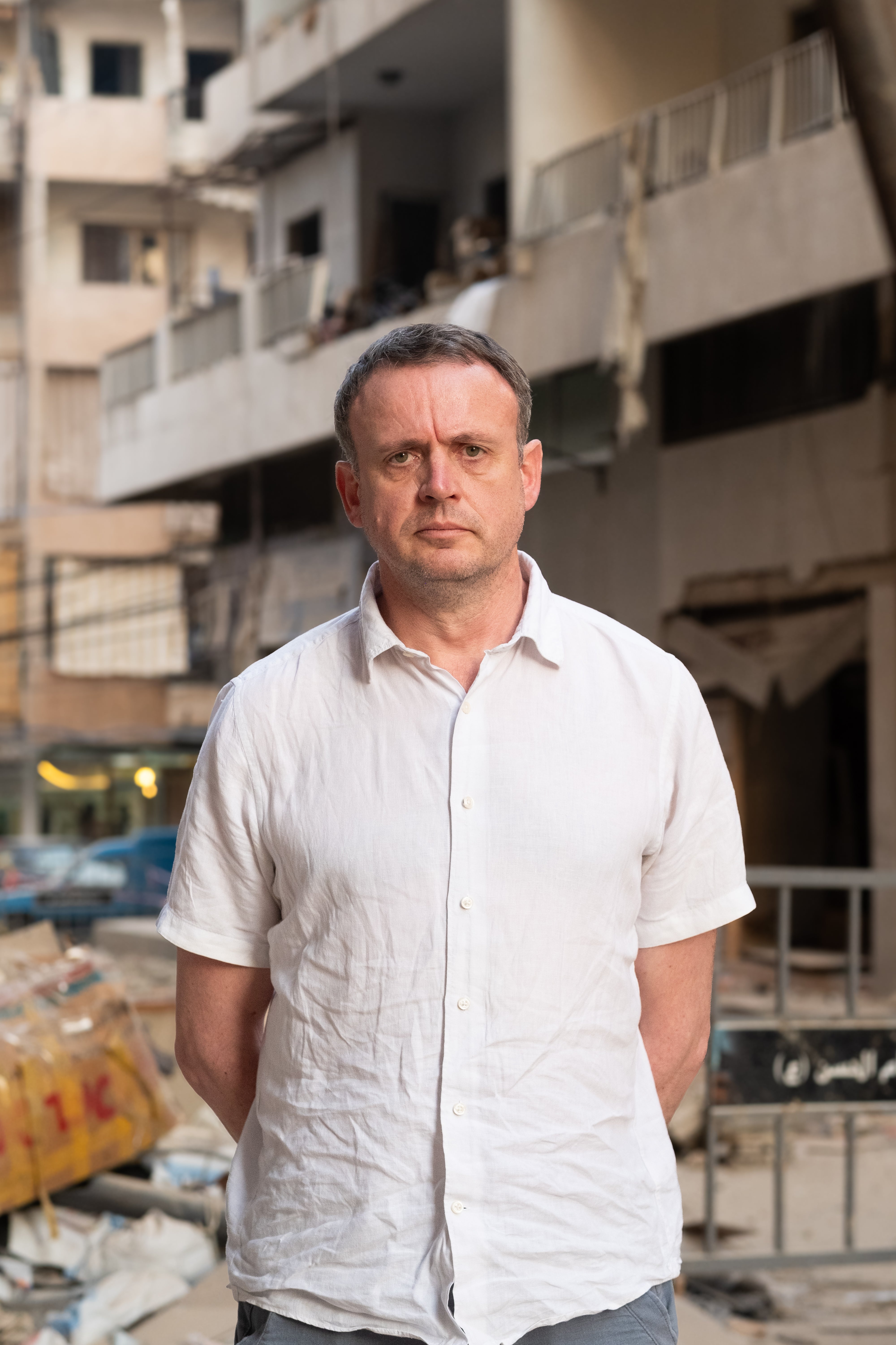 Christian Aid CEO Patrick Watt is photographed in front of a building destroyed by Israeli airstrikes in Beirut