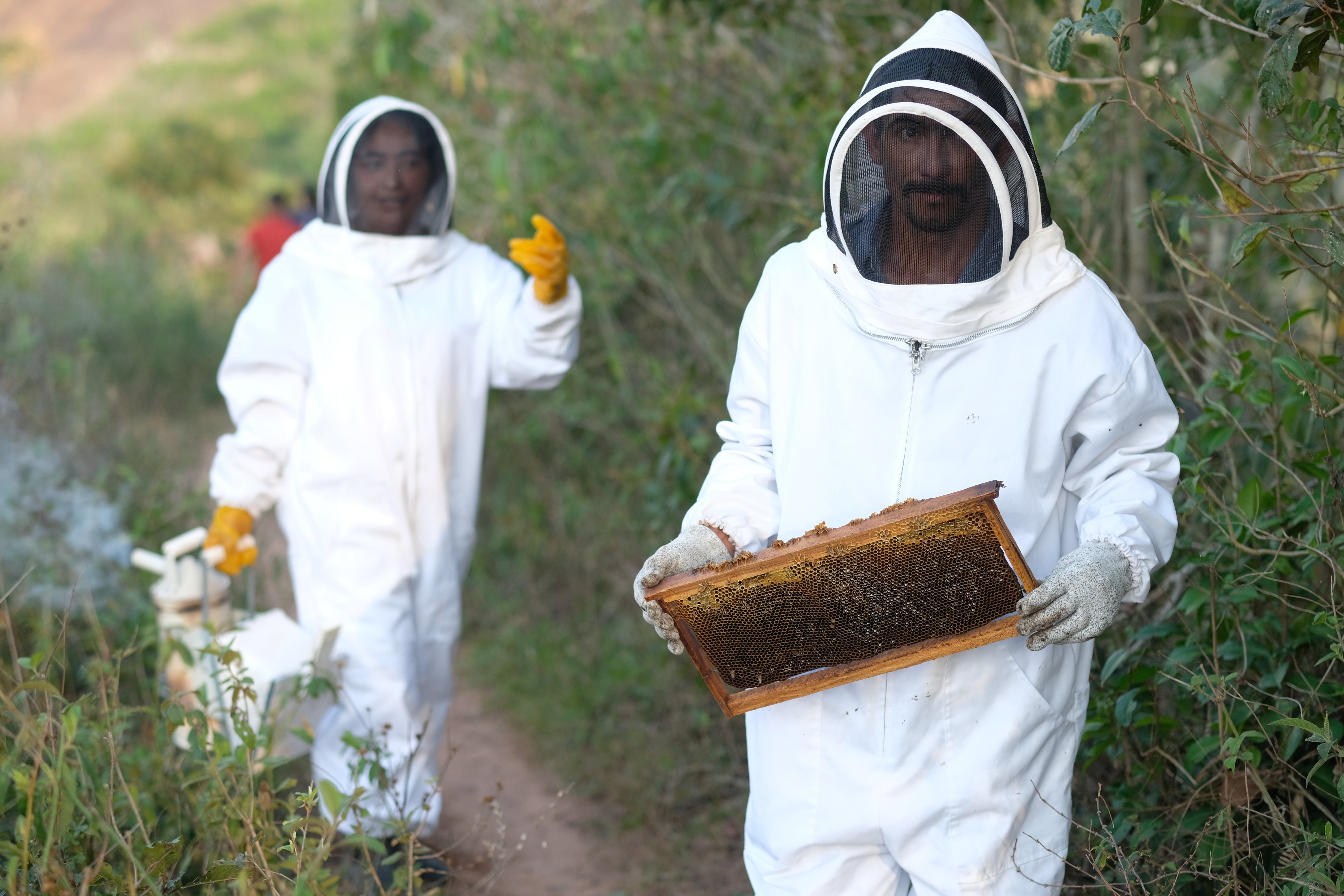 Maria Ramirez and Jose Garcia with honey from their beehives in Honduras. The beehive was installed with support from Christian Aid as a drought-proof means of generating income, as their region faces ever more unpredictable weather