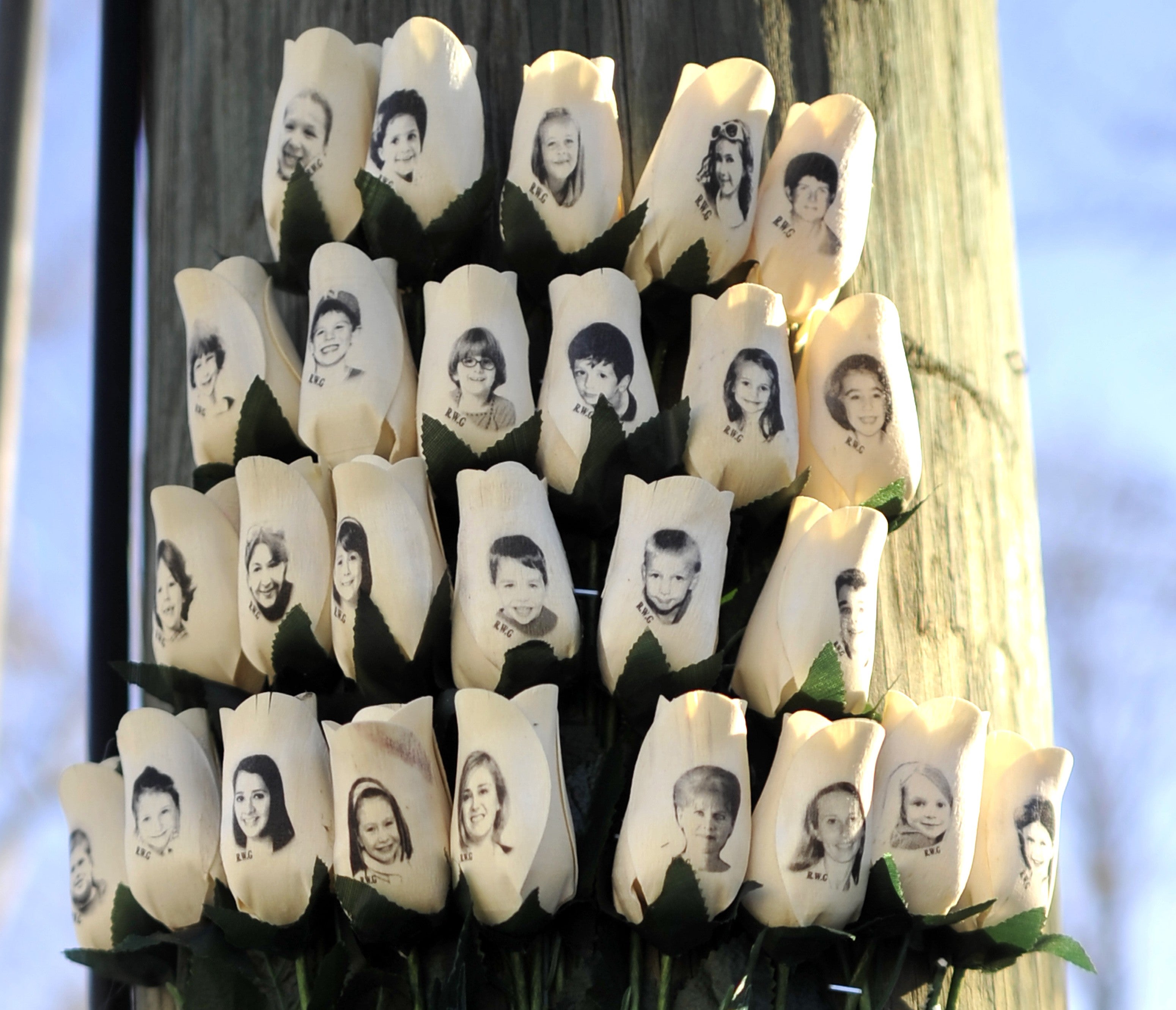 Roses with the faces of the Sandy Hook Elementry students and adults killed are seen on a pole in Newtown, Connecticut on January 3, 2013