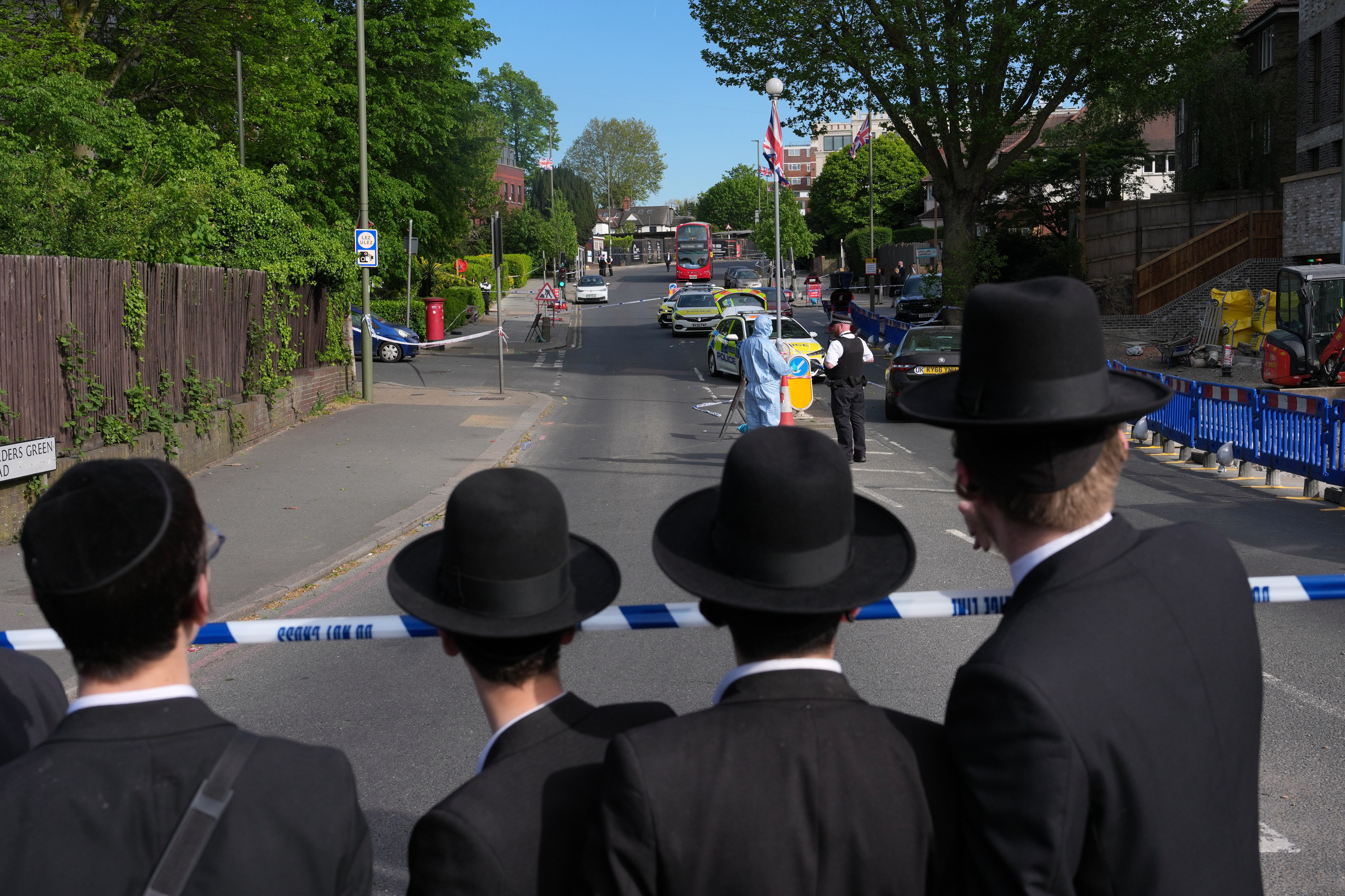 Members of the Jewish community watching police at the crime scene