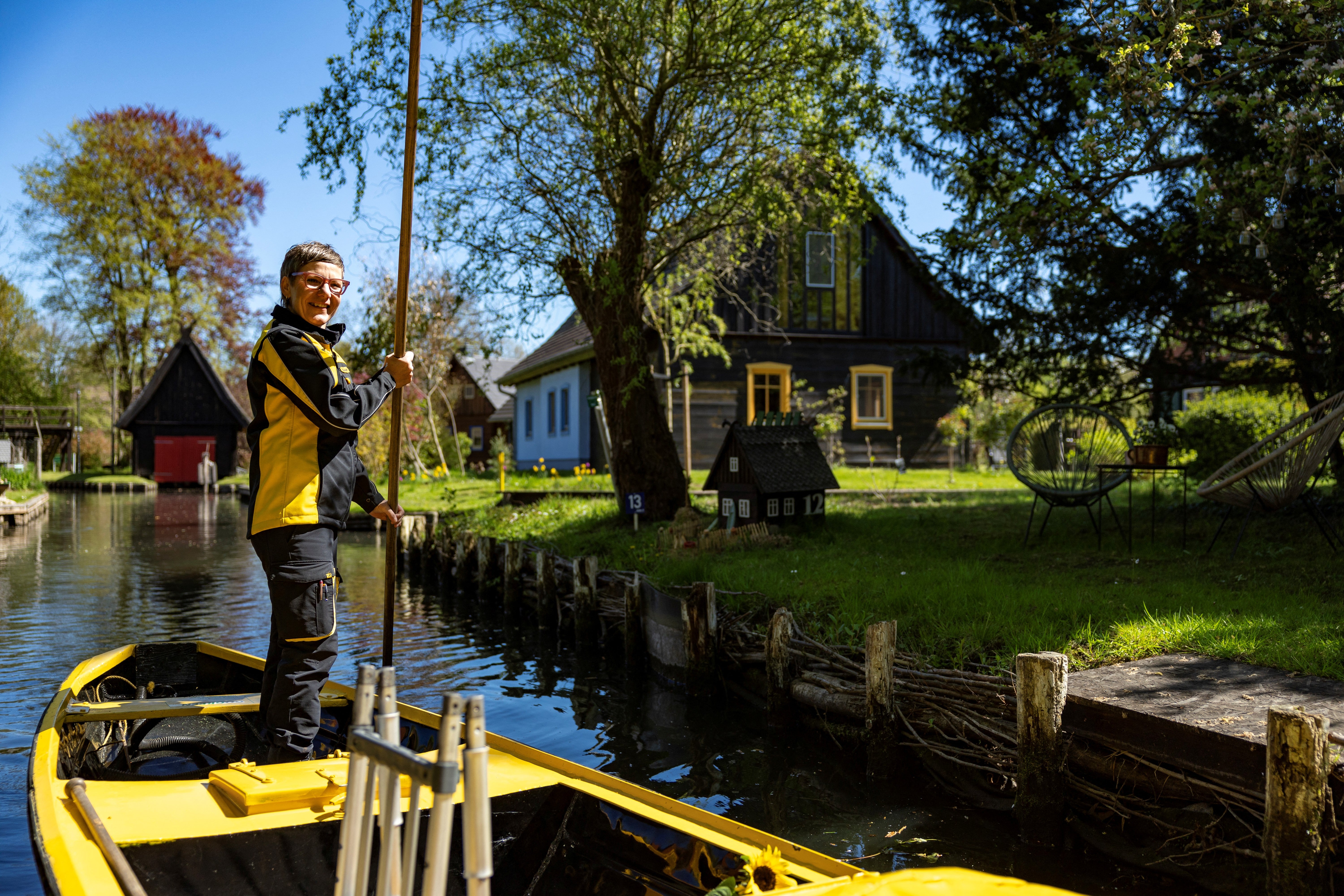 Deutsche Post delivery staff member Andrea Bunar manoeuvers her vessel as she makes the season opening delivery tour of the Spreewald barge postal delivery service