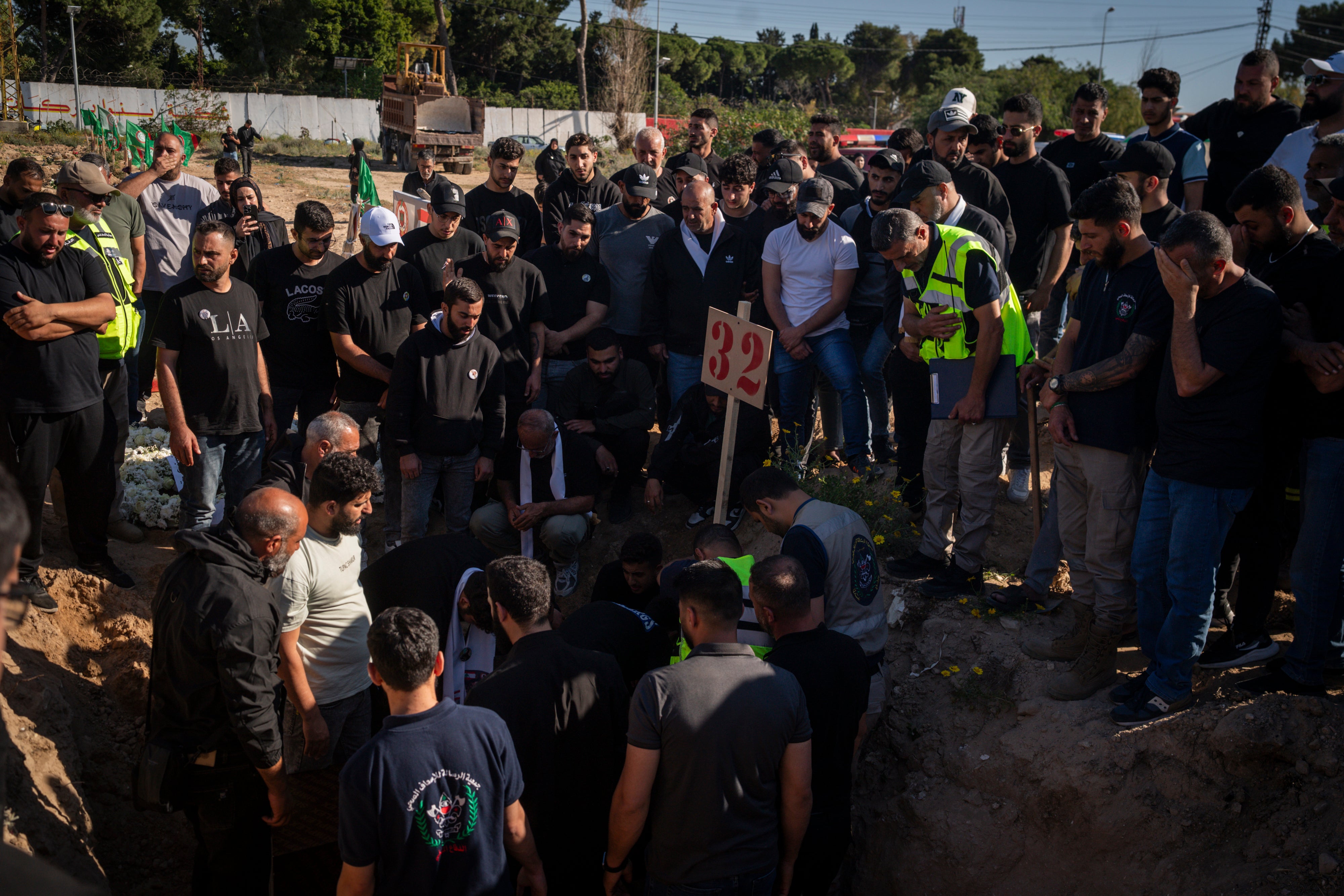 Mourners gather during a funeral at a makeshift cemetery for Hussein Ghadbouni, one of three members of the Lebanese Civil Defense who were killed in an Israeli airstrike on Tuesday